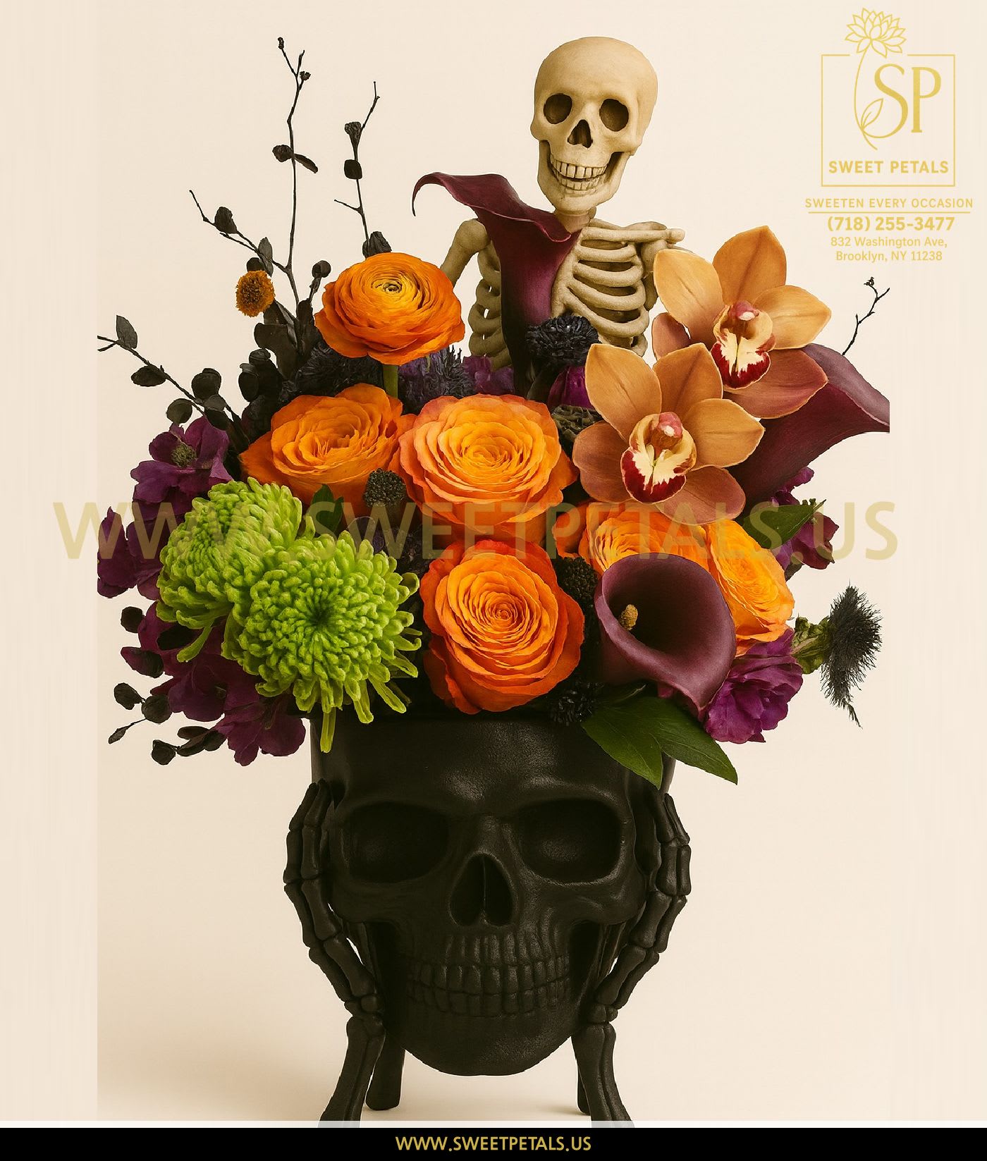 Skeleton Garden Luxe Arrangement by SweetPetals - The Skeleton Garden Luxe Arrangement by SweetPetals is a hauntingly beautiful fusion of elegance and edge. Designed in a matte black skull vase, this bold Halloween showpiece features a mix of vibrant orange roses, deep purple calla lilies, green chrysanthemums, exotic orchids, and rich seasonal accents — all brought to life by a playful skeleton centerpiece.  Each flower in bouquet is hand-selected by expert SweetPetals florists for freshness, vibrance, and flawless detail. The contrast of fiery oranges and moody purples creates a stunning visual balance — perfect for Halloween décor, autumn parties, or as a gift for someone who loves dramatic floral art.  This Flowers by SweetPetals creation combines spooky sophistication with luxury craftsmanship, making it an unforgettable centerpiece for any modern celebration. Whether displayed on a dining table or gifted as a conversation-starter, it’s sure to leave a lasting impression.   SweetPetals – Sweeten Every Occasion