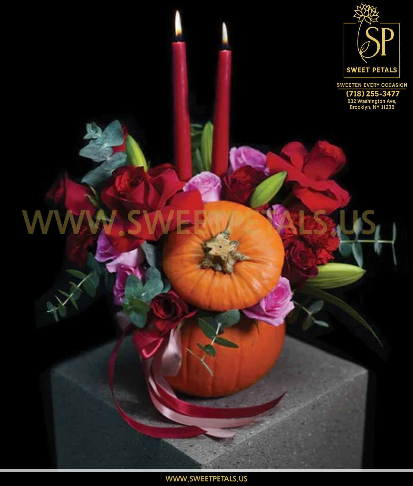Pumpkin Candlelight Floral Arrangement by SweetPetals - The Pumpkin Candlelight Floral Arrangement by SweetPetals captures the cozy spirit of autumn with a romantic twist. Crafted inside a natural pumpkin base, this stunning design features lush red roses, soft pink blooms, vibrant carnations, and rich greenery — elegantly accented by two glowing taper candles.  Each flower in bouquet is hand-selected by expert SweetPetals florists to ensure freshness, color, and seasonal beauty. The flickering candlelight paired with the deep fall tones creates a warm, intimate ambiance — perfect for Thanksgiving dinners, Halloween celebrations, or cozy fall gatherings.  Whether adorning your dining table, gifting a loved one, or brightening your home décor, the Pumpkin Candlelight Floral Arrangement by SweetPetals combines artistry and elegance in every detail. Its charming pumpkin vase and sophisticated flower mix make it the ideal autumn centerpiece for lovers of timeless style.   SweetPetals – Sweeten Every Occasion
