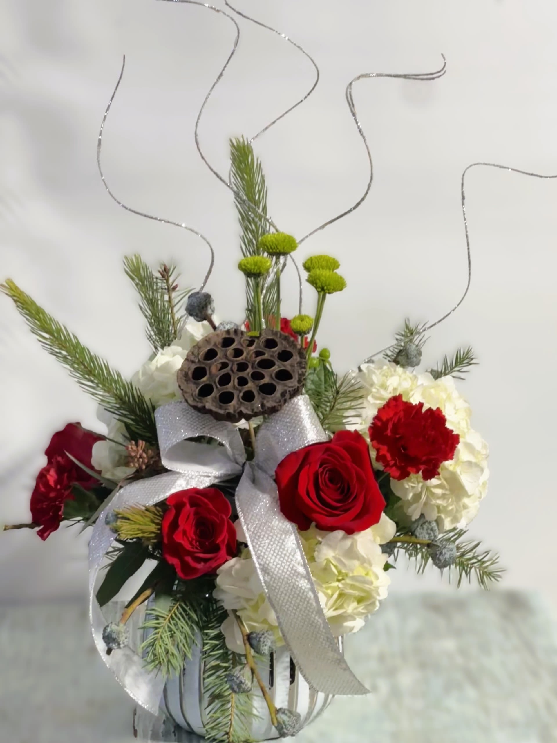 Christmas #9 - Festive  arrangement of fresh cut flowers designed in a white ceramic container.