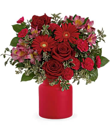 Teleflora's Enchanted Red - Talk about well-red! Arranged in a charming frosted glass jar, this enchanting red rose bouquet livens up any occasion. This arrangement includes red roses, dark pink alstroemeria, hot pink miniature carnations, miniature red carnations, pitta negra, seeded eucalyptus and lemon leaf. Delivered in Teleflora's Savannah Jar.
