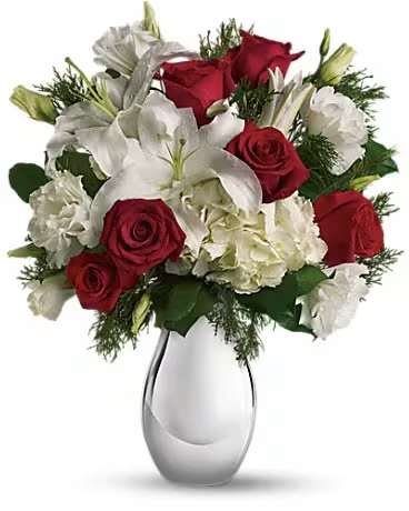 Teleflora's Silver Noel Bouquet - Simple, classic and yet magnificently merry, this festive array of red and white flowers in a silver reflections vase is a gift they'll love - now and forever. The keepsake vase will bring a sparkle to many holidays to come. The lovely Christmas bouquet includes white hydrangea, red roses, white oriental lilies and white lisianthus accented with flat cedar.