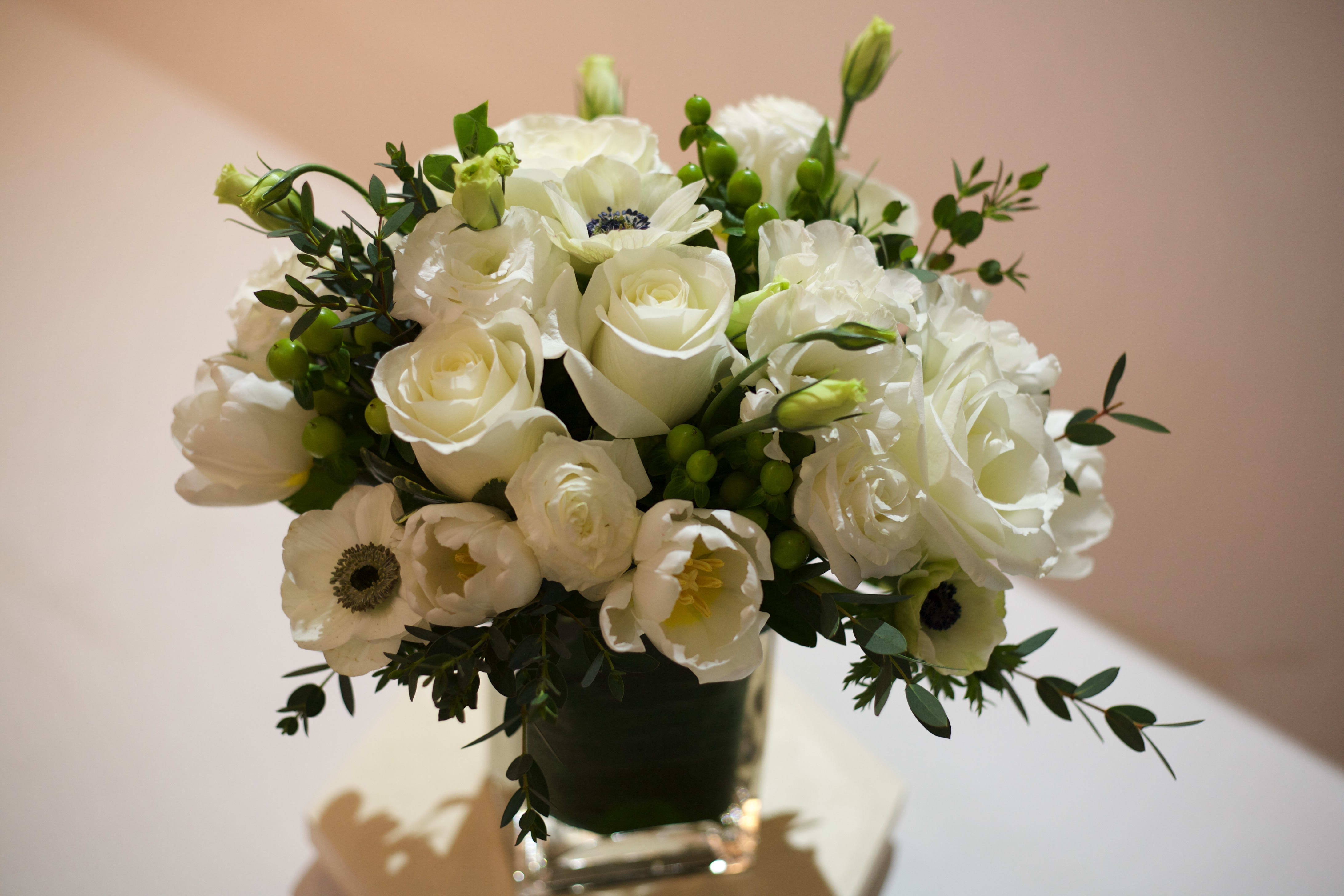 Pure Whites - A mix of the season's best white flowers -- including full tulips and delicate anemones, with roses, of course -- to express the truest of romantic intentions. White flowers are offset by green hypericum berries and lisianthus buds.