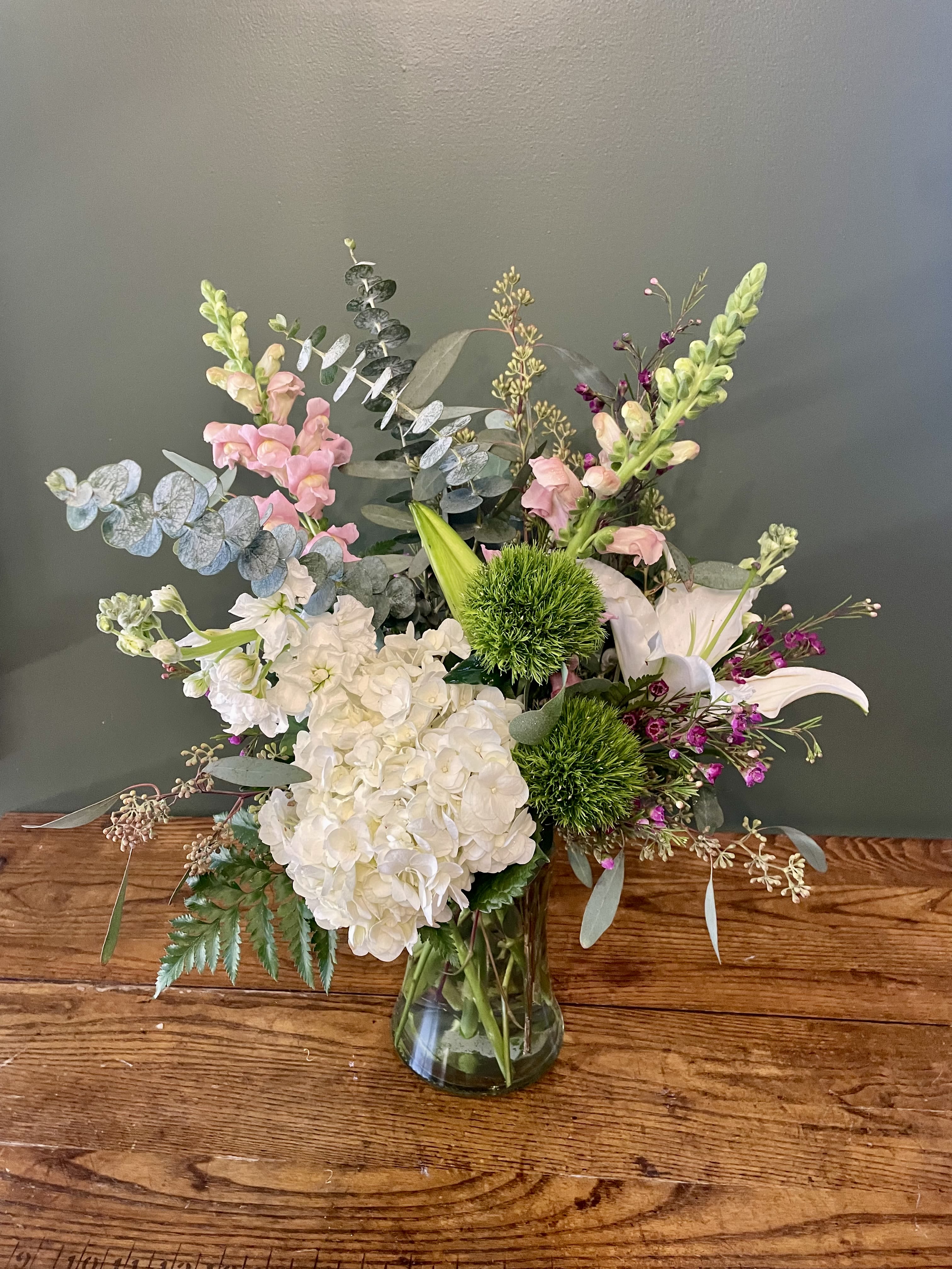 Simply Sweet - Beautiful floral arrangement in a clear vase with lilies, hydrangeas, snapdragon, green trick, and eucalyptus.