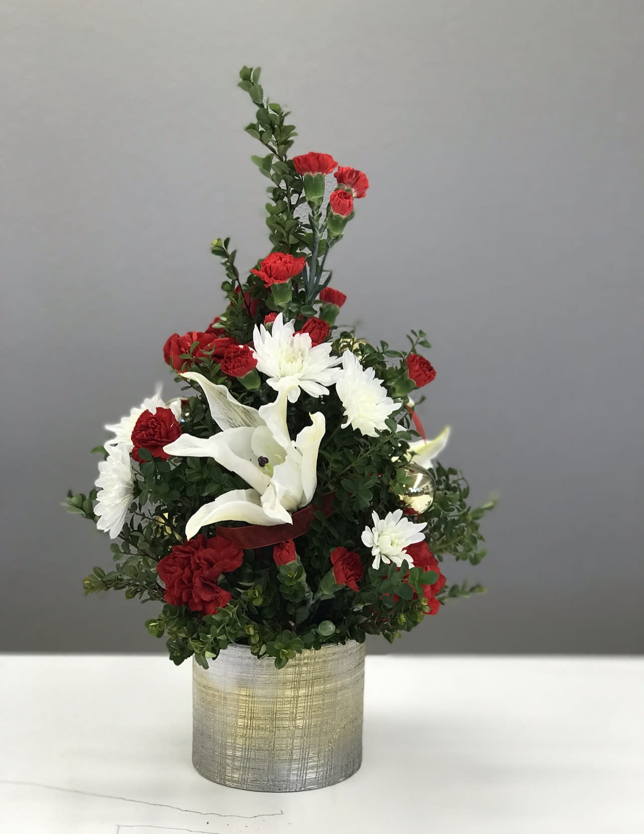 Winter Fresh - Celebrate your christmas with this prety bouquet of red carnations and white mums, hand arranged in a gorgeos container.