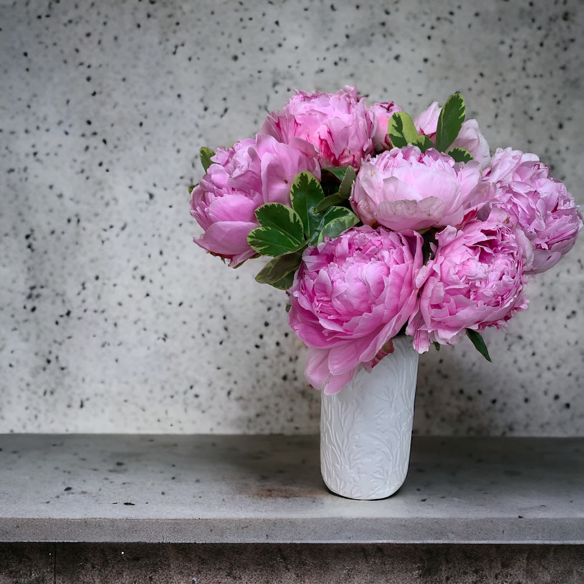 Peony Perfection - Ten stunning peonies nestled in a beautiful white vase etched with delicate flowers. 