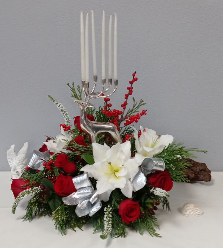Silver Reindeer Candle Centerpiece - Make the season bright with silver antler taper candles and radiant holiday blooms. Filled full red roses, white lilies other flowers, and holiday greens. This elegant, silver reindeer is a collector's keepsake. 