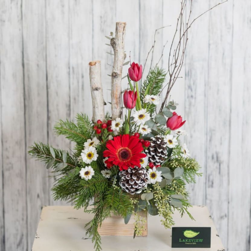 Birch - A rustic wooden container with birch poles, pinecones, and unique seasonal blooms make for a perfect winter arrangement!  Approximate Size: 23"T x 12"W