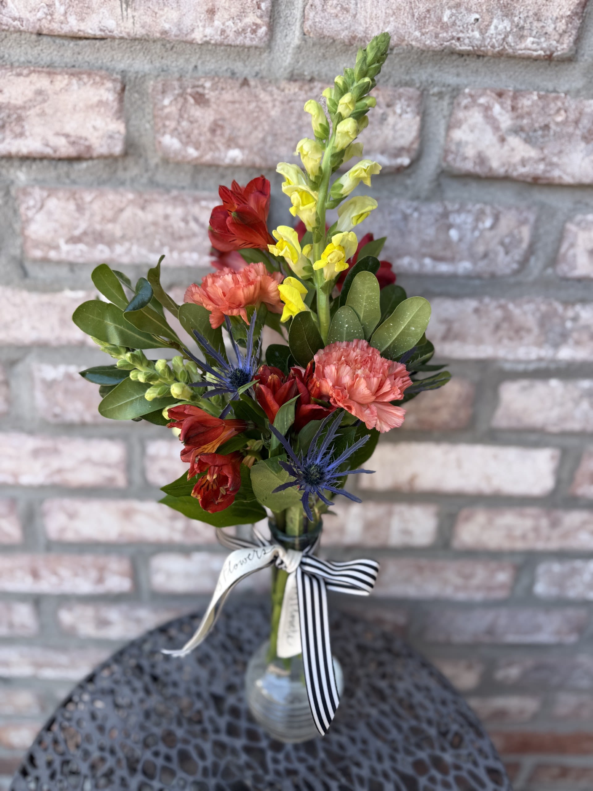 New! Mini Meadow - A little bit of fall, all arranged in a tall bud vase.  Filled with the likes of Snapdragons, alstromeria, carnations and more. Measuring approximately 21" tall. 