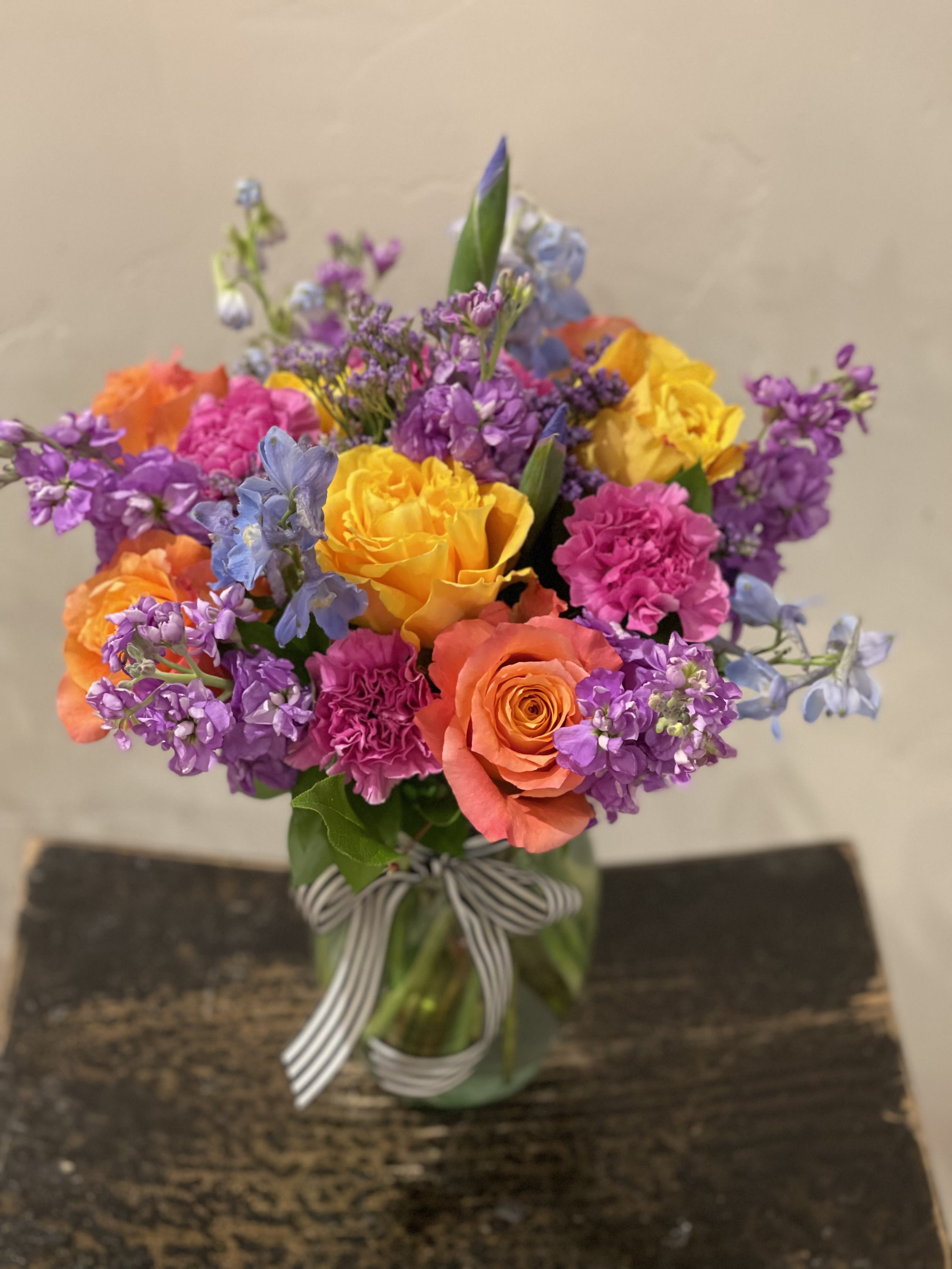 Celebration Blooms - A colorful, eye catching design of roses, stock, Iris, carnations and delphinium make up this beautiful, fragrant arrangement. 