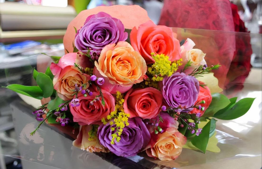 Simply Magical Dozen Mixed Rose Bouquet - One dozen mixed in color, fresh, crisp roses flown in fresh  from our growers in Ecuador. Hand selected and processed to ensure freshness and longevity.  We  then hand tie them with assorted greenery and wrap them in  beautiful euro papers and  cellophane. Tied off with a bow.  A true  classic.  Does not come with a vase. Colors will vary depending on availability. 