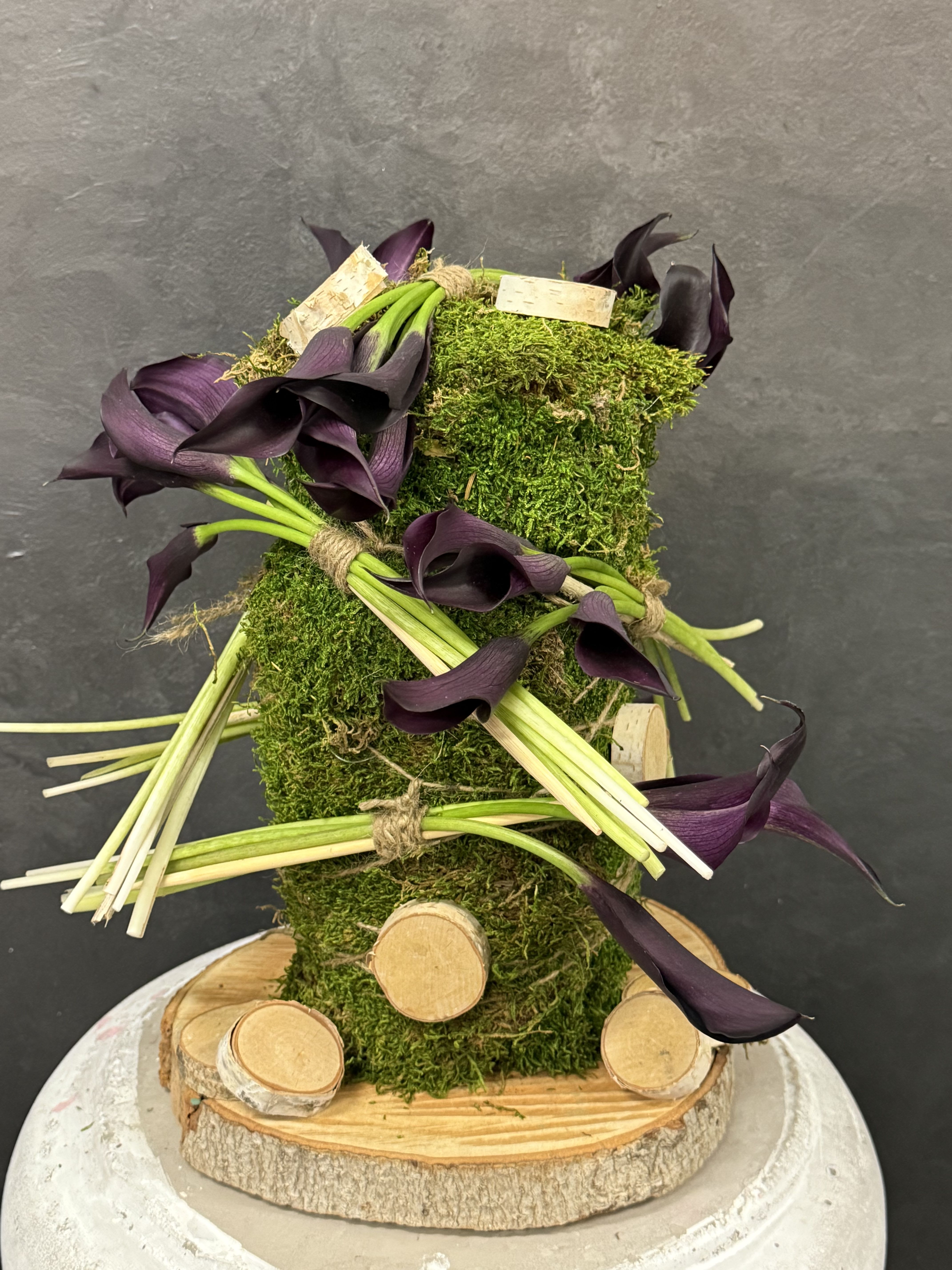 Unique arrangement  - Purple calla lilies accented with natural wood details — a refined arrangement where modern elegance meets organic beauty.