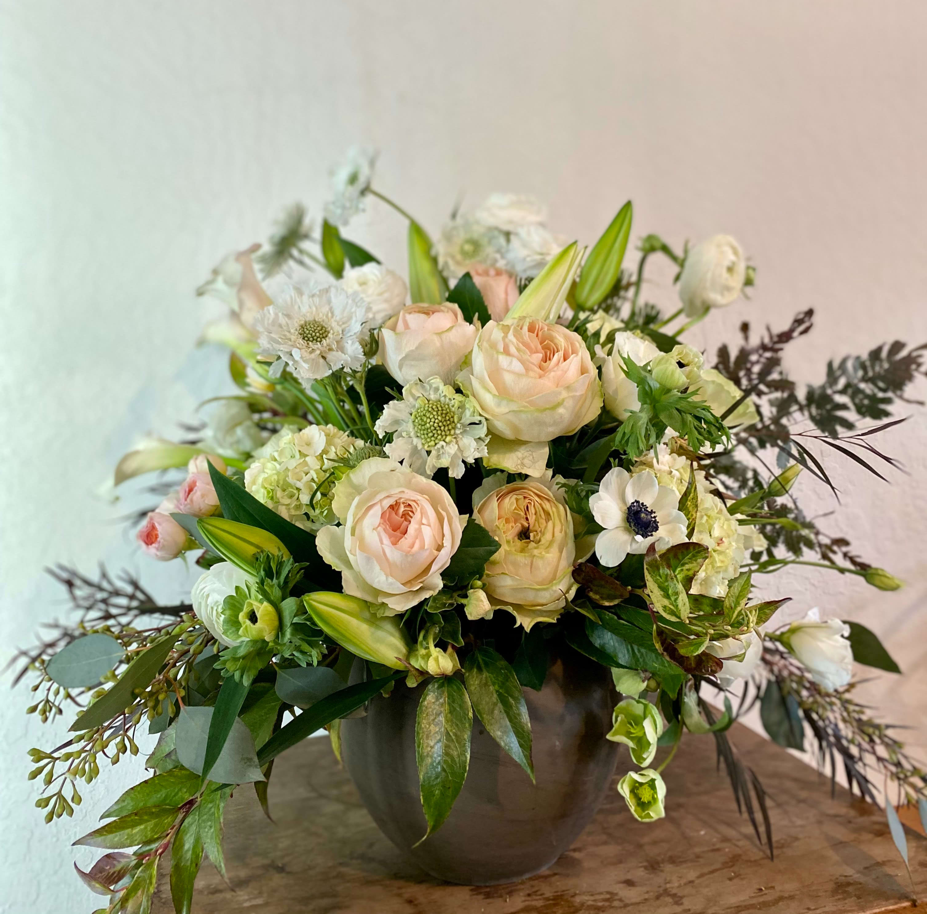 Sachi - Happiness - Say hello to Sachi. Sachi means happiness in Japanese and the Sachi floral arrangement from Momo's Flowers and More is our favorite way to express it. In these challenging times we find happiness can be elusive. We take it where we can find it. We crave the genuine. And we think we found it in Sachi, a delightfully curated selection that spells out happiness not too loudly, but sweet and clear and genuine as a baby's smile. Get Sachi and you'll be smiling too. (Sachi comes in an elegant ceramic vase and features garden roses and other seasonal blooms.)