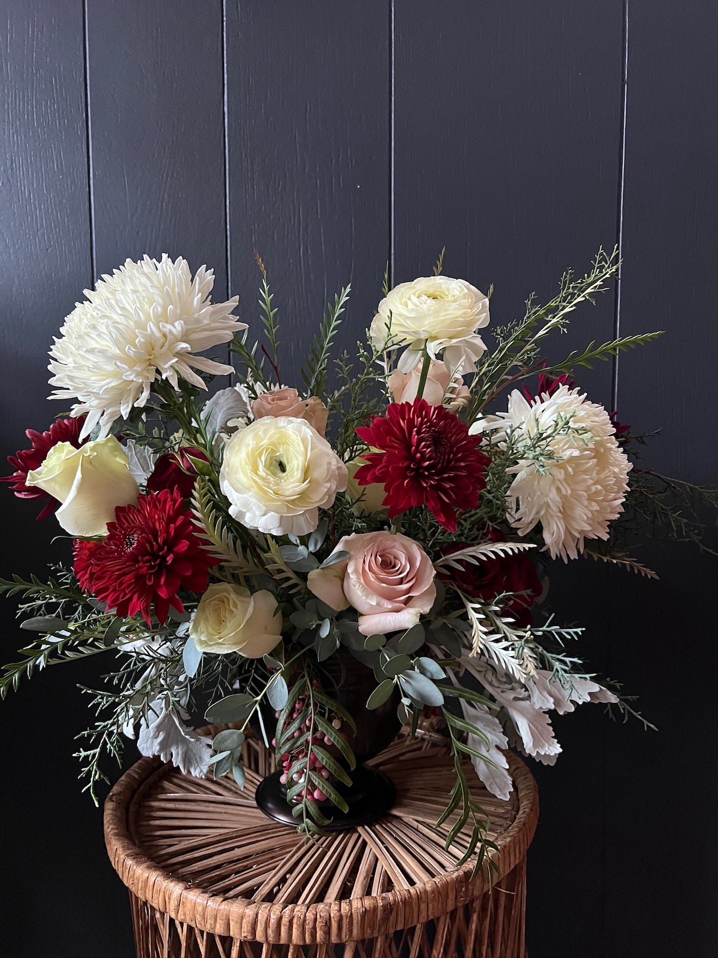 FESTIVE COMPOTE LUXE ARRANGEMENT - The festive compote is artfully arranged with the season's best flowers and foliage in a metal or ceramic footed bowl. This arrangement will contain red but the rest of the festive palette will (beautifully) vary.