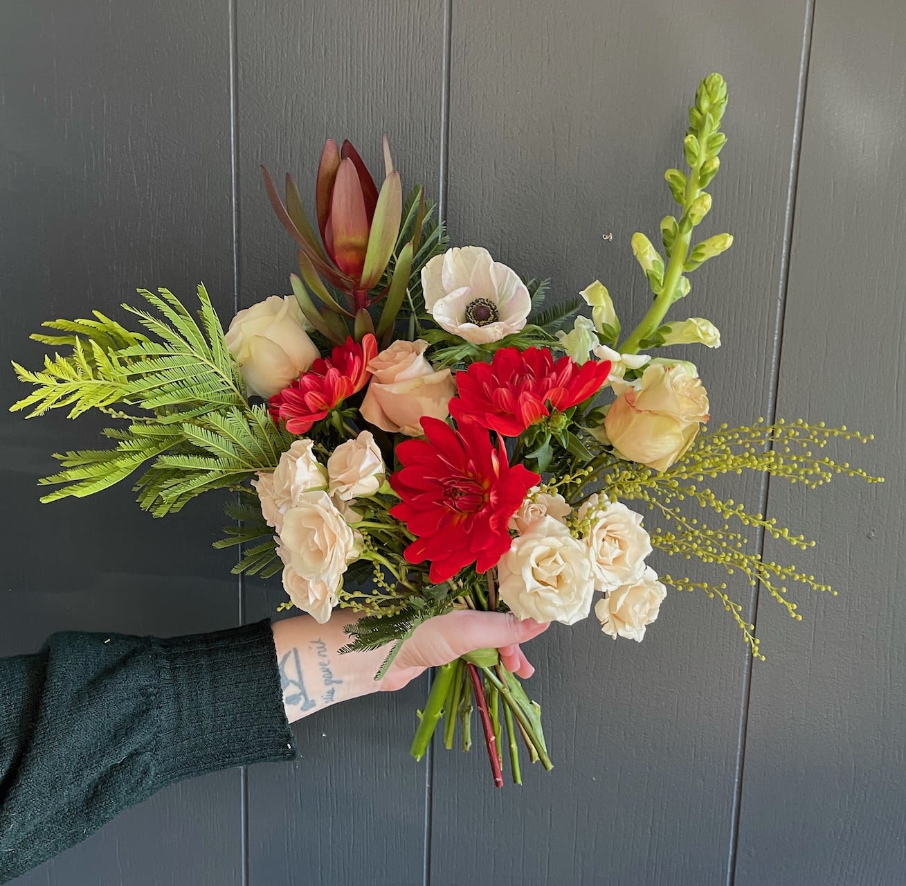 FESTIVE BOUQUET - The festive bouquet is a gathering of the season's best flowers and foliage wrapped in tissue. This bouquet will contain red but the rest of the festive palette will (beautifully) vary.