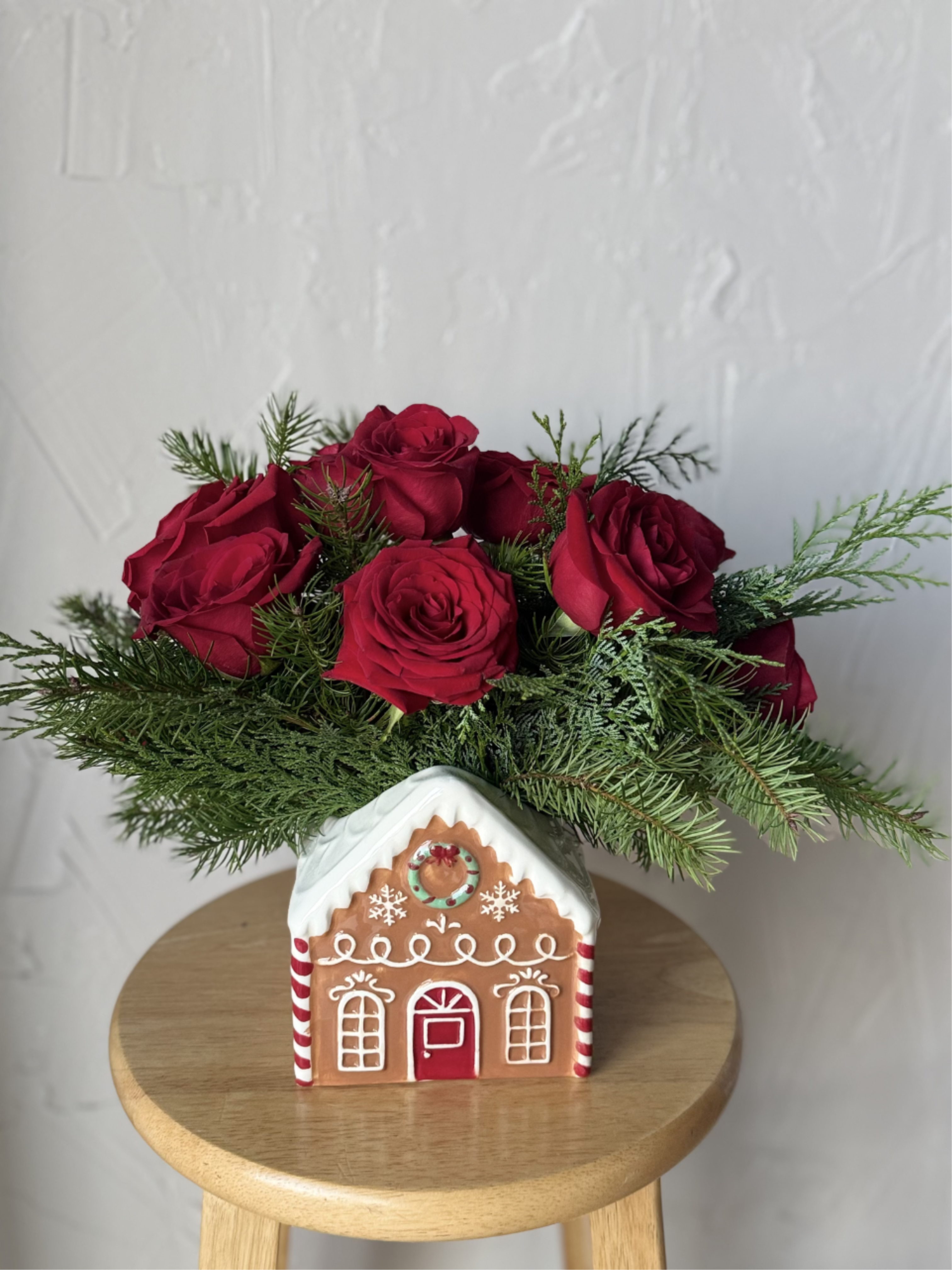 Ceramic Gingerbread Winter House Rose Arrangement - Christmas themed greenery and fresh cut red roses in a ceramic vase