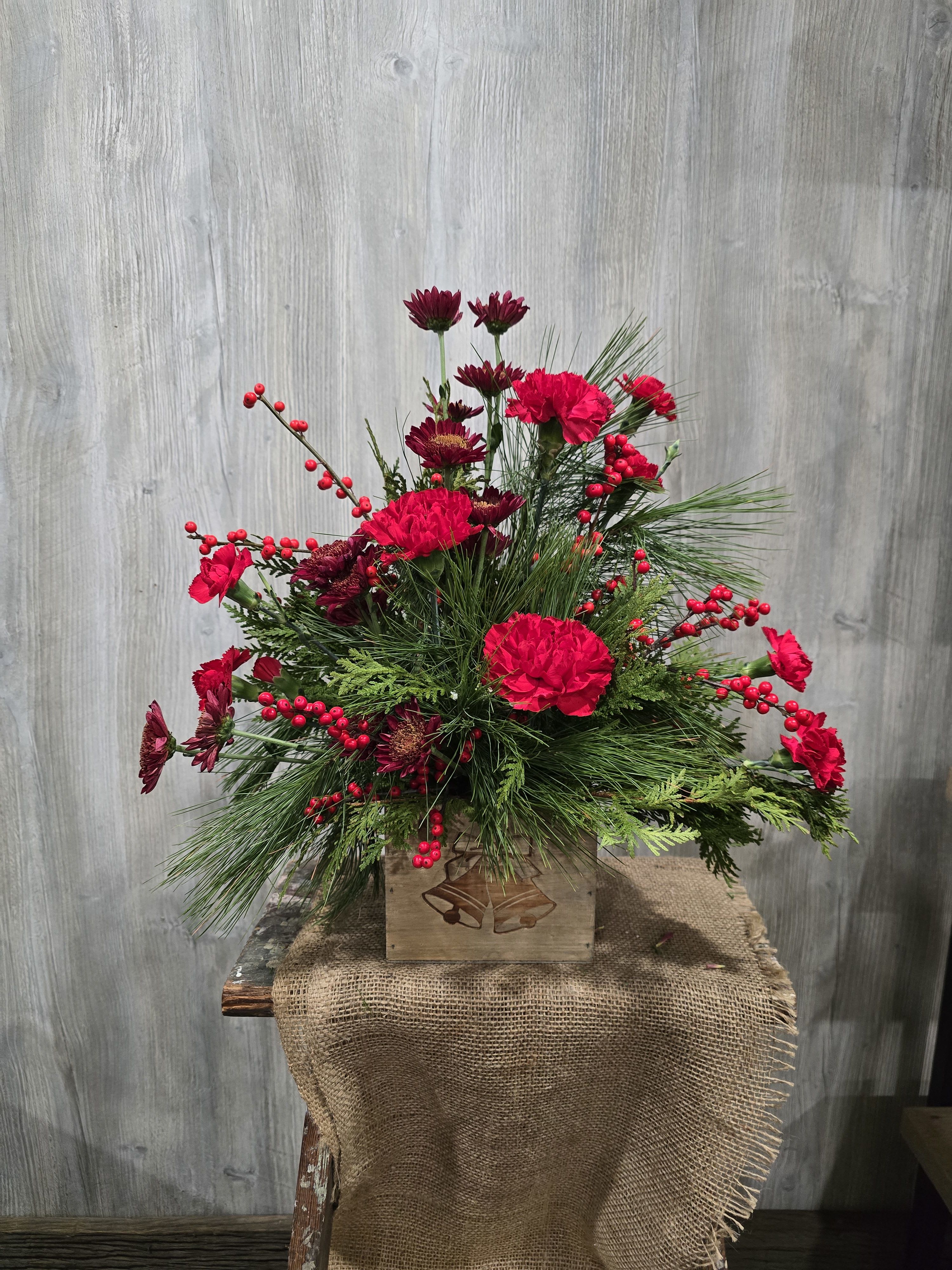 Holiday Bells  - A beautiful wooden box with christmas bells on the front. Full of fresh pine and flowers! Deluxe and premium pricing includes more flowers. 