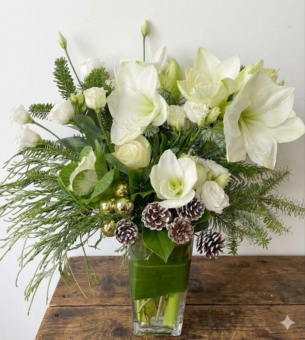 Evergreen Elegance - Graceful and refined, Evergreen Elegance is a sophisticated winter arrangement that blends timeless white blooms with lush seasonal greenery. Striking white amaryllis are beautifully paired with roses, lisianthus, fresh evergreens, and natural pinecone accents, creating a design that feels both festive and serene. Accents of glossy greens and subtle holiday touches add warmth, while the clean glass vase keeps the look modern and polished.  Perfect for holiday décor, winter celebrations, or an elegant seasonal gift, Evergreen Elegance brings natural beauty and quiet luxury to any home or office.  Details: 	•	Features white amaryllis, roses, lisianthus, winter evergreens, and pinecone accents 	•	Designed in a clear glass vase with a clean, modern silhouette 	•	Tall, elegant arrangement with a soft winter color palette 	•	Designed by Sunny Florists  Please note: Flower varieties and accent elements may vary slightly due to seasonal availability, while maintaining the overall design style and color palette.
