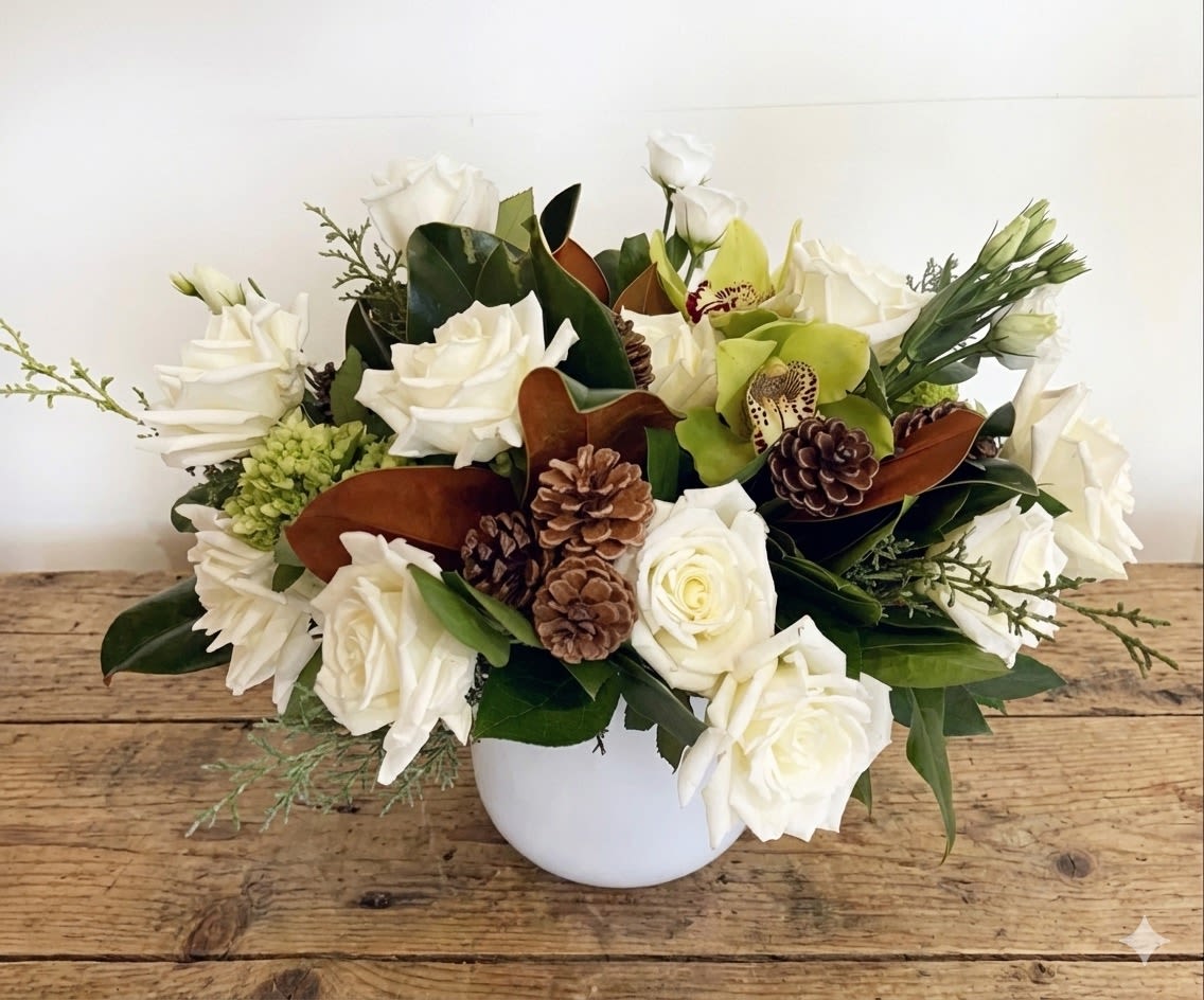 Montana Forest  - Inspired by the quiet beauty of nature, Montana Forest is a lush, earthy arrangement that brings the feeling of a winter woodland indoors. Creamy white roses and seasonal white blooms are thoughtfully paired with green cymbidium orchids, textured pinecones, magnolia leaves, and layered greenery for a rich, organic look. Designed in a modern white ceramic bowl, this arrangement feels natural, refined, and timeless.  Perfect for winter décor, sympathy gestures, or an elegant seasonal centerpiece, Montana Forest offers a serene and sophisticated presence in any home or office.  Details: 	•	Features white roses, green cymbidium orchids, white seasonal blooms, magnolia leaves, pinecones, and fresh greenery 	•	Designed in a modern white ceramic bowl 	•	Full, low-profile arrangement with natural woodland textures 	•	Designed by Sunny Florists  Please note: Flower varieties and greenery may vary slightly due to seasonal availability, while maintaining the overall color palette and design style.