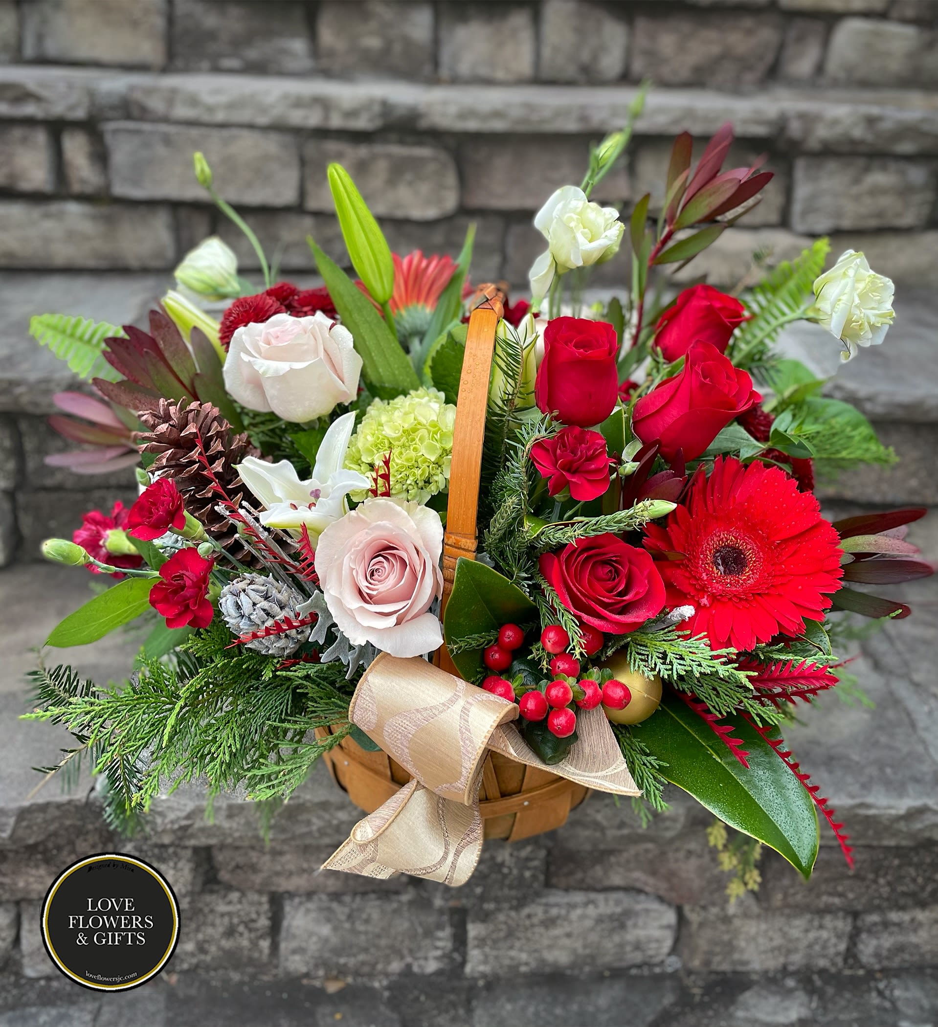 Be Merry Basket - Send the spirit of the holidays made in warm classic colors of red, white, and greens of roses, lilies, berries and more in a high-quality basket. 