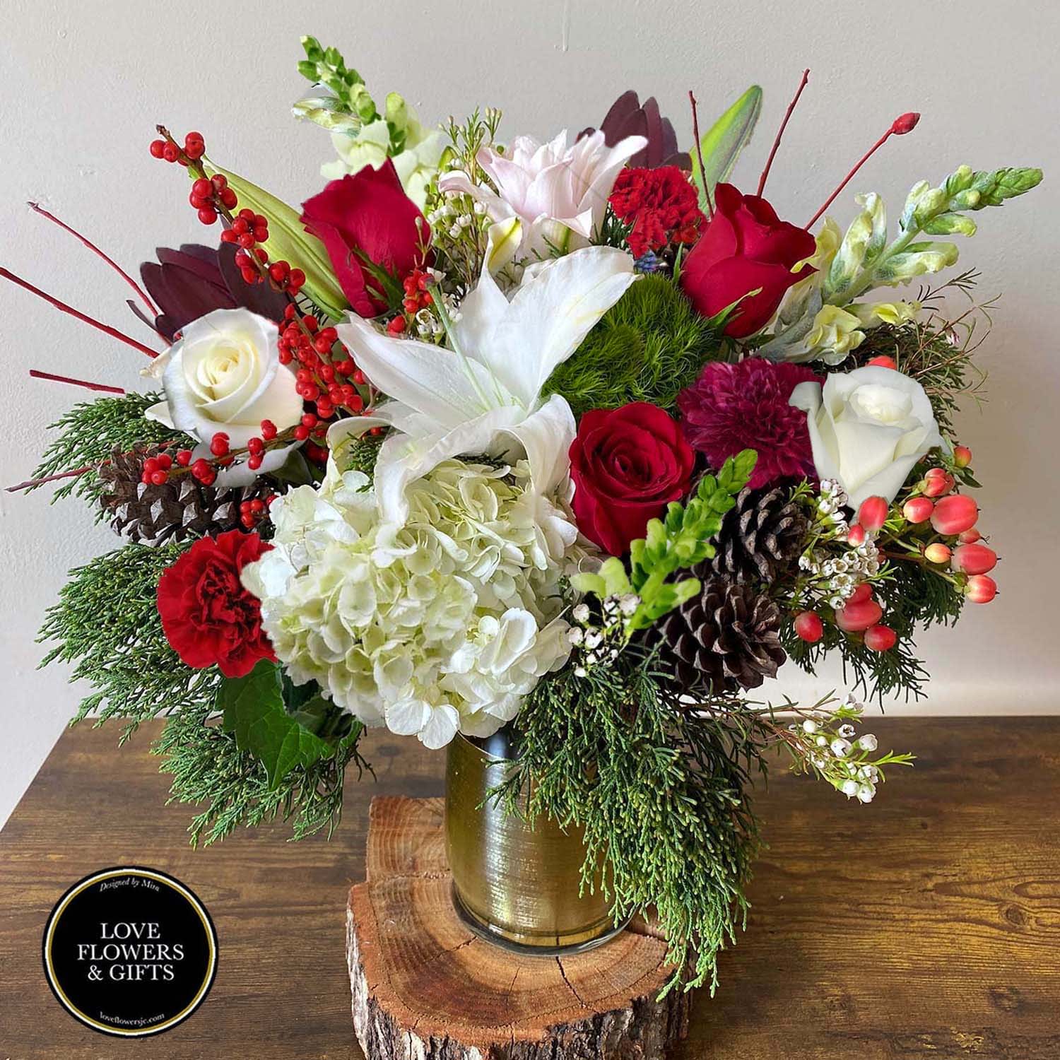Seasons' Greetings  - A classic yet elegant holiday arrangement made of shades of reds, whites and greens with fresh seasonal greenery designed in a glass vase wrapped in gold. Great gift for all kinds of occasions for the holiday