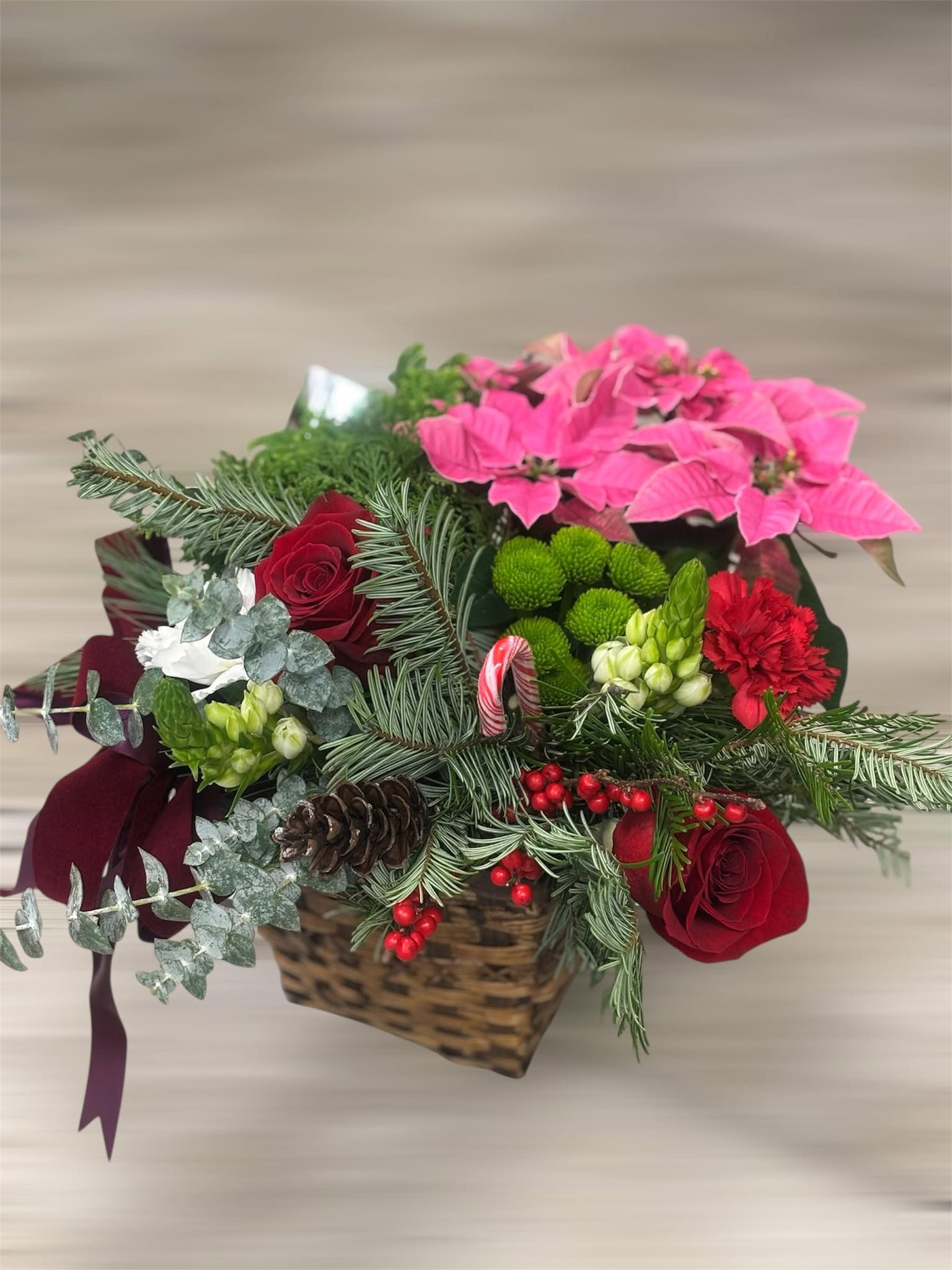 Holiday Cheer Basket - Bring the warmth and joy of the season into any space with our Holiday Cheer Basket. This festive arrangement is thoughtfully designed with rich red roses, vibrant pink poinsettia, seasonal evergreens, pinecones, and winter berries, all beautifully arranged in a natural woven basket. Accented with fresh textures and classic holiday details, it’s the perfect gift for spreading cheer, decorating a table, or welcoming guests during the holidays. Ideal for homes, offices, or as a heartfelt seasonal gift.