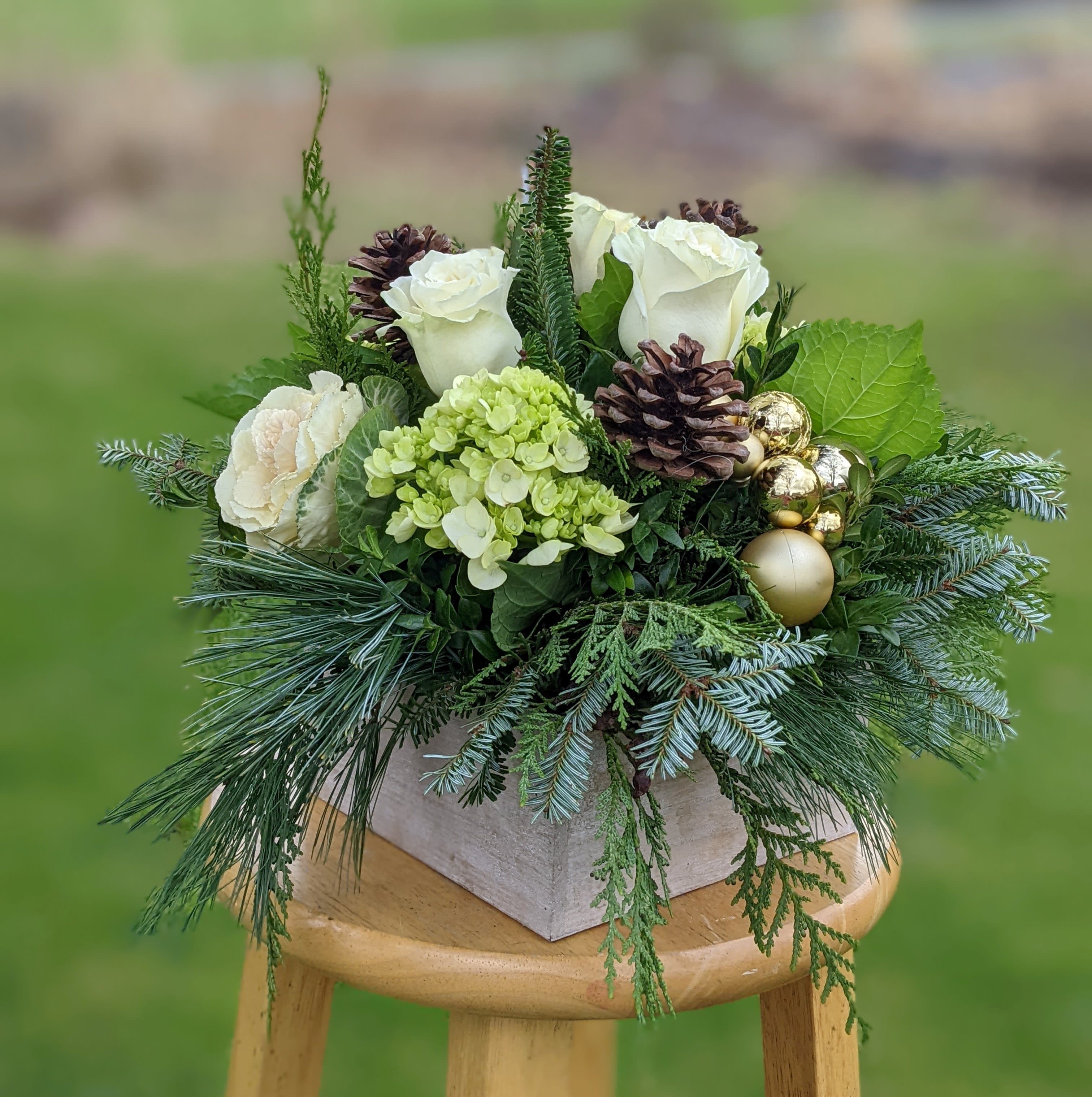 Rustic Winter Box - Our Rustic Wooden box is filled to overflowing with fragrant mixed winter greens, white and green seasonal flowers.  Holiday accents add texture and a bit of sparkle.