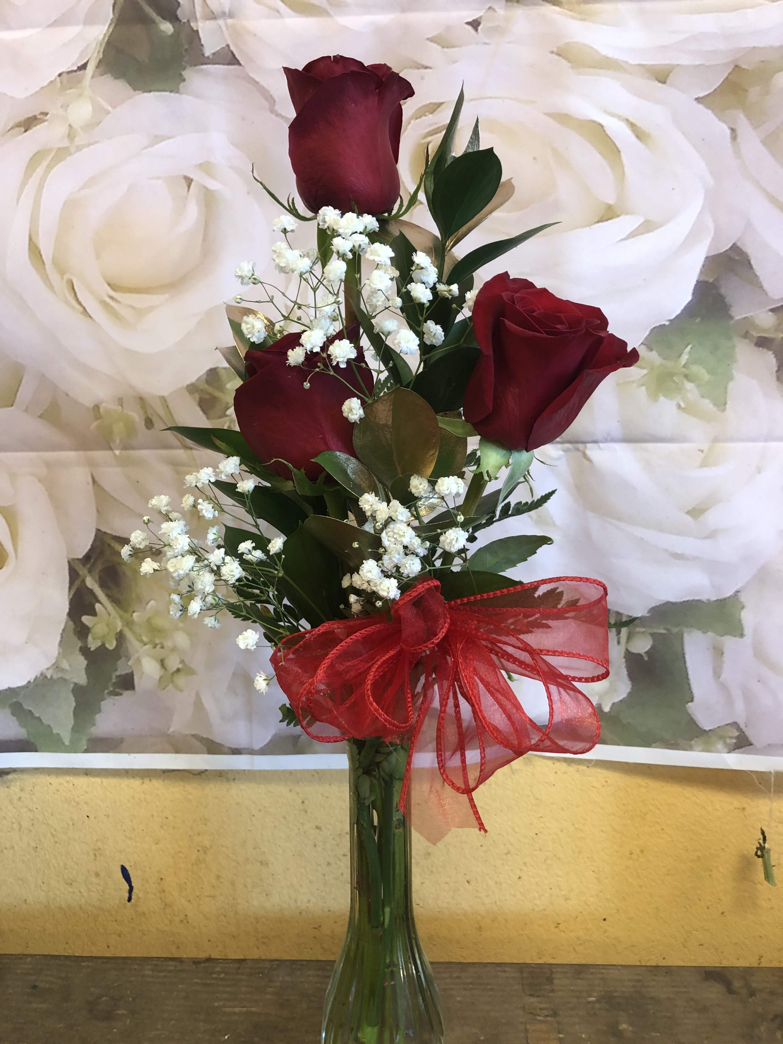 3 RED ROSES IN A VASE - 3 RED ROSES COMPACTED IN A VASE WITH GOLD RUSCUS AND BABY BREATH.  
