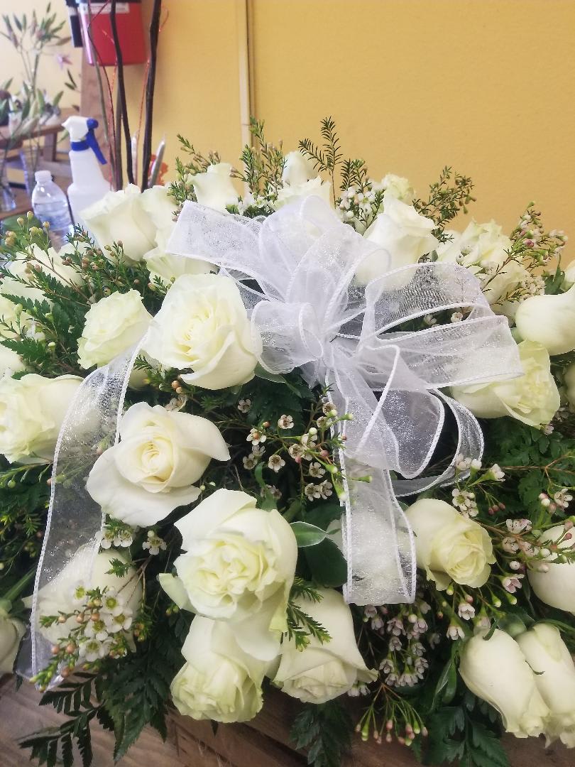 Casket 36 WHITE ROSES - 36 WHITE ROSES with Filler and WHITE BOW.  Casket measures about 32 inches long and 24 inches wide.   (NOTE if you want another color roses instead of white this is possible) just add this information under special instructions. 