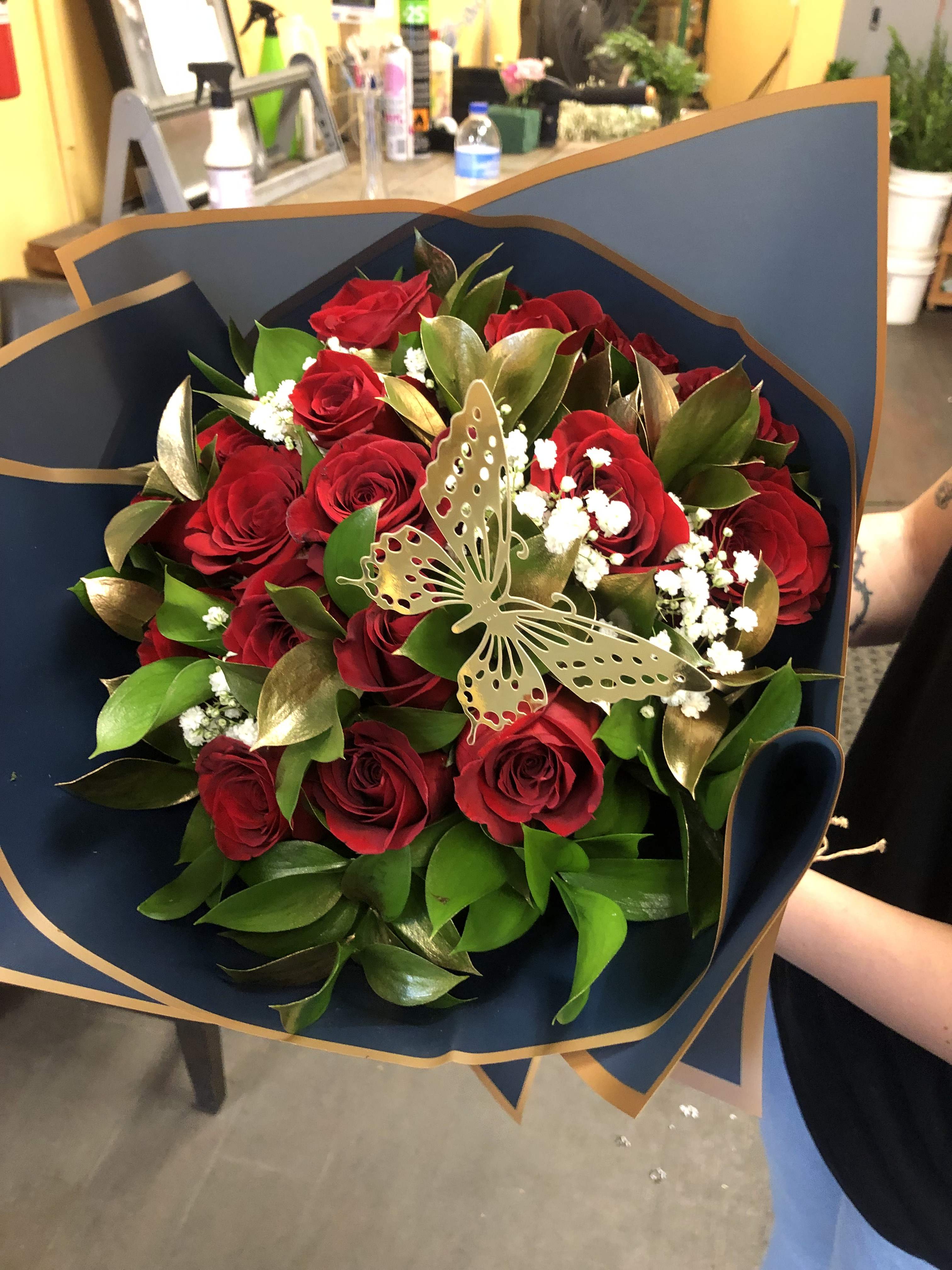 12 RED ROSES WRAP ( NO VASE) - 12 RED ROSES with Baby Breath and Gold Ruscus Leaves wrapped in color paper (NO VASE) Included  NOTE: Deluxe Price includes 18 RED ROSES Premium Price includes 24 RED ROSES