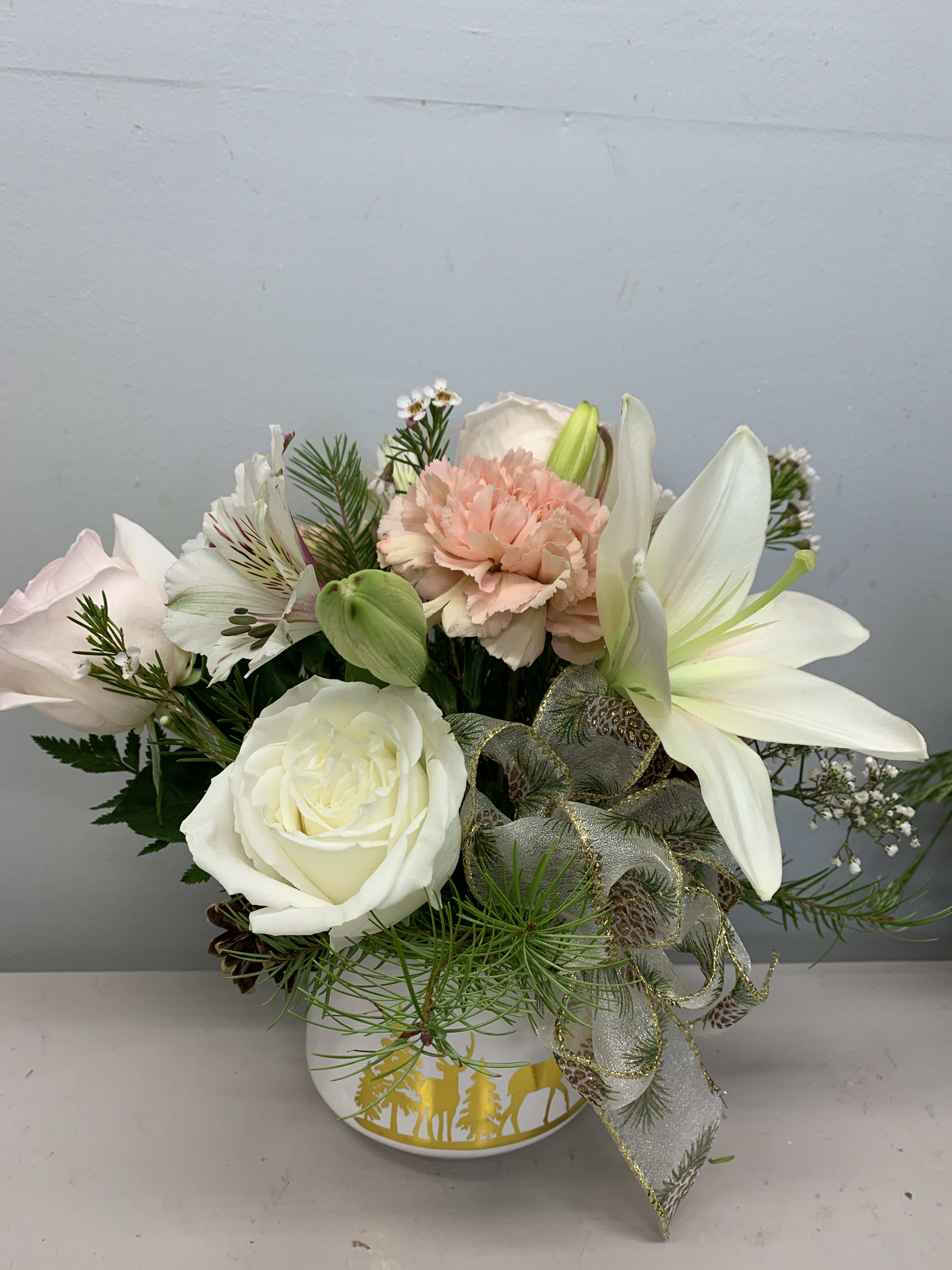 Winter Delight - Soft and serene flower arrangement in a white with gold reindeer design ceramic container 