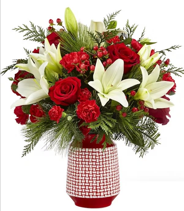 Sweet Joy Bouquet - Add some "sweet joy" to the holidays this year with this popular red, white and green bouquet. A red ceramic vase with raised white woven pattern holds a classic red and white Christmas palette of blooms. Flowers include white Asiatic lilies, red roses and red carnations. Extras include red hypericum berries and assorted seasonal greens like cedar, pine and spruce.