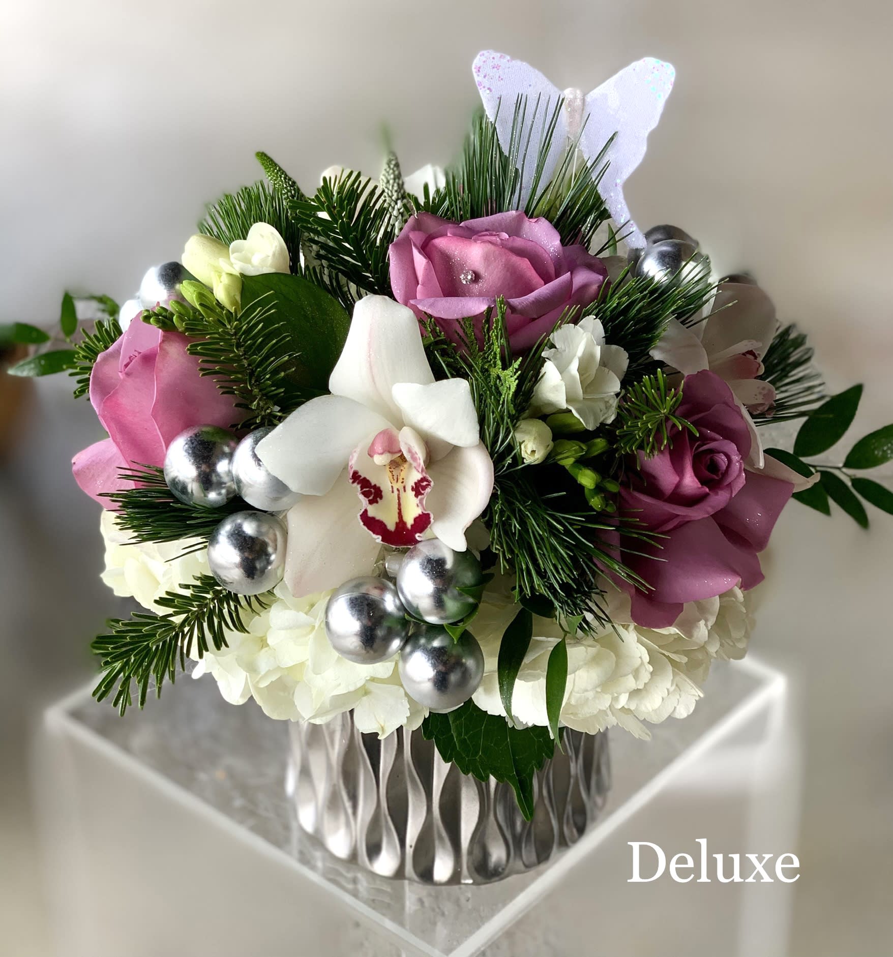 Lavender Holiday - Roses, Ornaments Xmas Greens - We may not be able to spend time with our girlfriends this year but that doesn't mean we can show them how much we appreciate them. Send this festive arrangement with lavender or pink roses, pinecones, silver ornaments and more. 