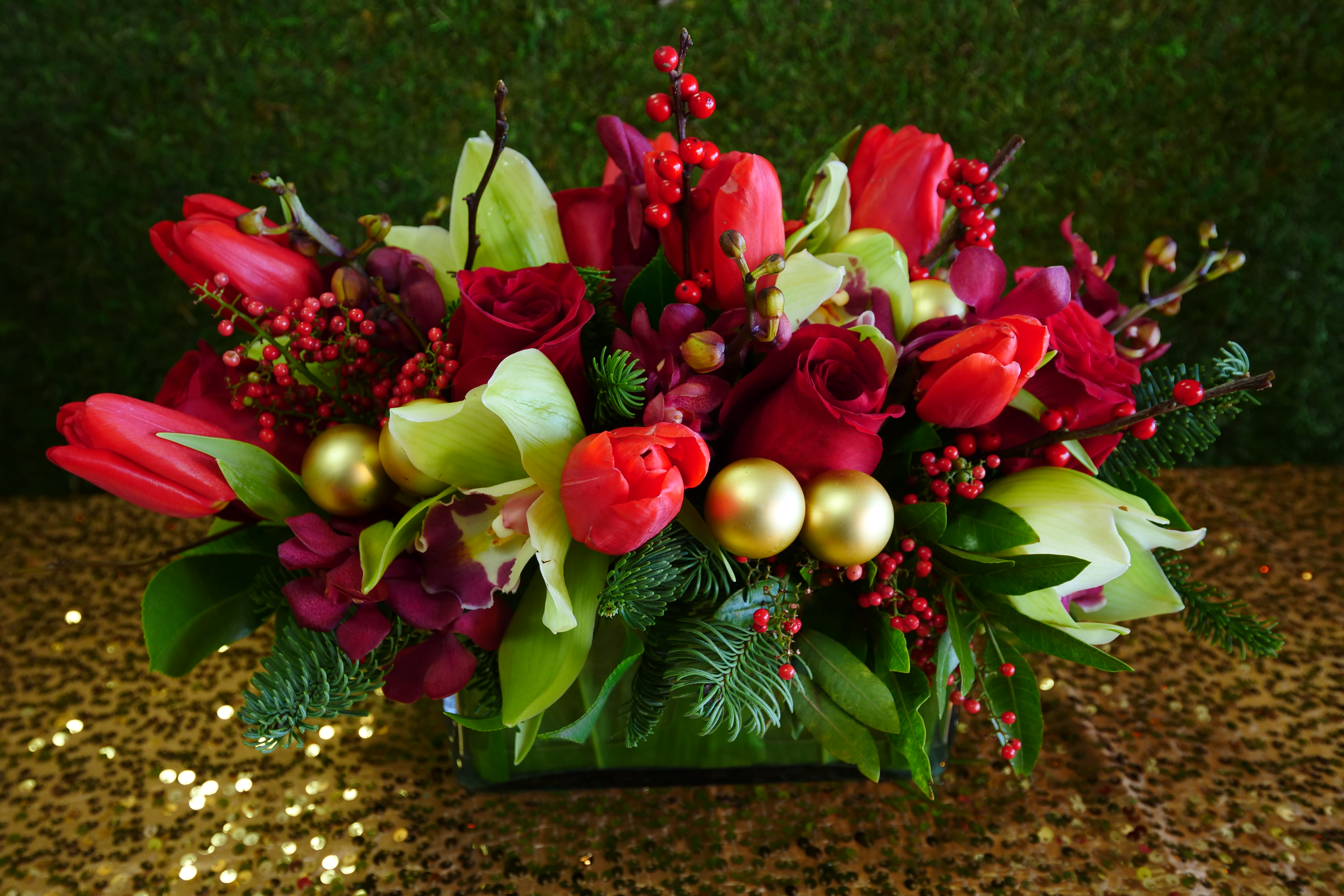 Holiday Design 10 - The holidays are here, and so is this elegant design featuring festive ornaments among an array of orchids, roses, tulips, xmas greens and more. A great gift to send from afar, hand delivered, of course! Or a great addition to the dinner table. 