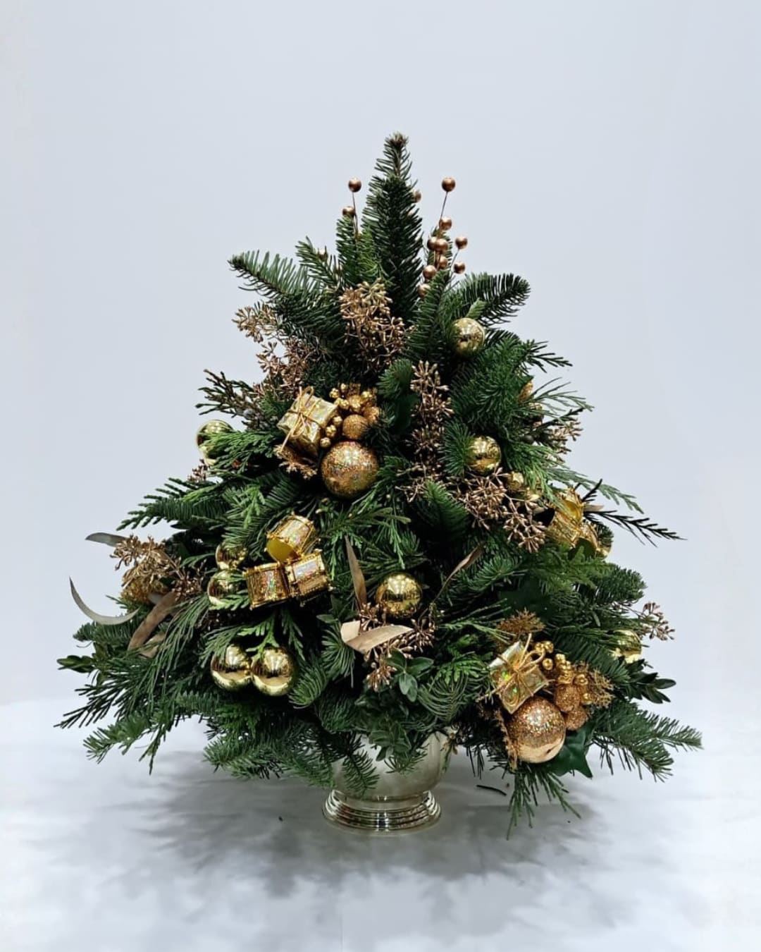 The Golden Christmas Tree - This is a mini christmas tree that was hand made with real pine branches. It was put together in a tree-shape manner. It is adorned with gold ornaments and gold eucalyptus. 