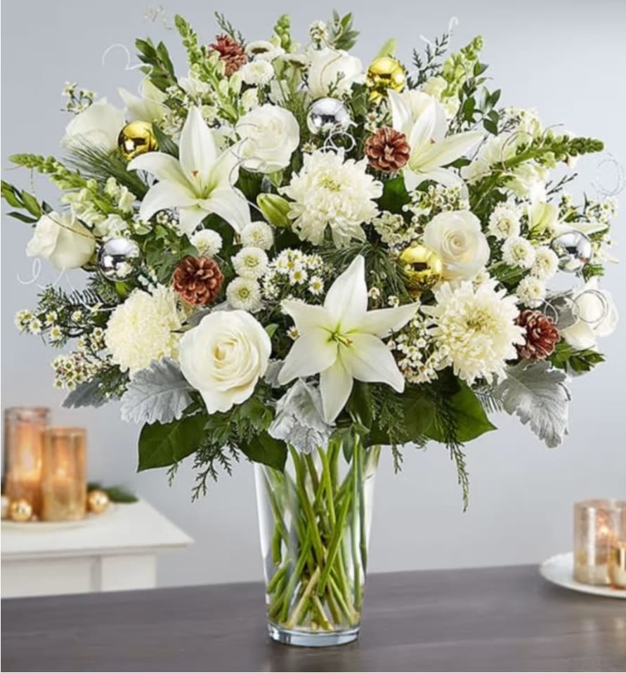 Dazzling Winter Wonderland Flower Arrangement - Dazzle them with a winter wonderland of beautiful blooms. Our luxurious new arrangement captures the beauty of the season in every last detail. Standing almost two feet tall, it’s overflowing with a blizzard of white blooms, shimmering silver &amp; gold ornaments and pinecone accents to play up its natural beauty while adding plenty of texture. What a memorable gift to share during this magical time of year.