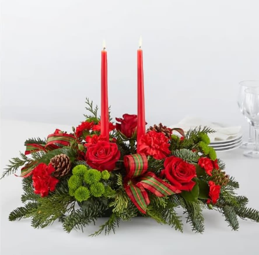 By the Candlelight Centerpiece - Let time fly By the Candlelight centerpiece as new holiday memories are made. What better way to commemorate the joyful homecoming than with classic red roses and lush evergreen accents!