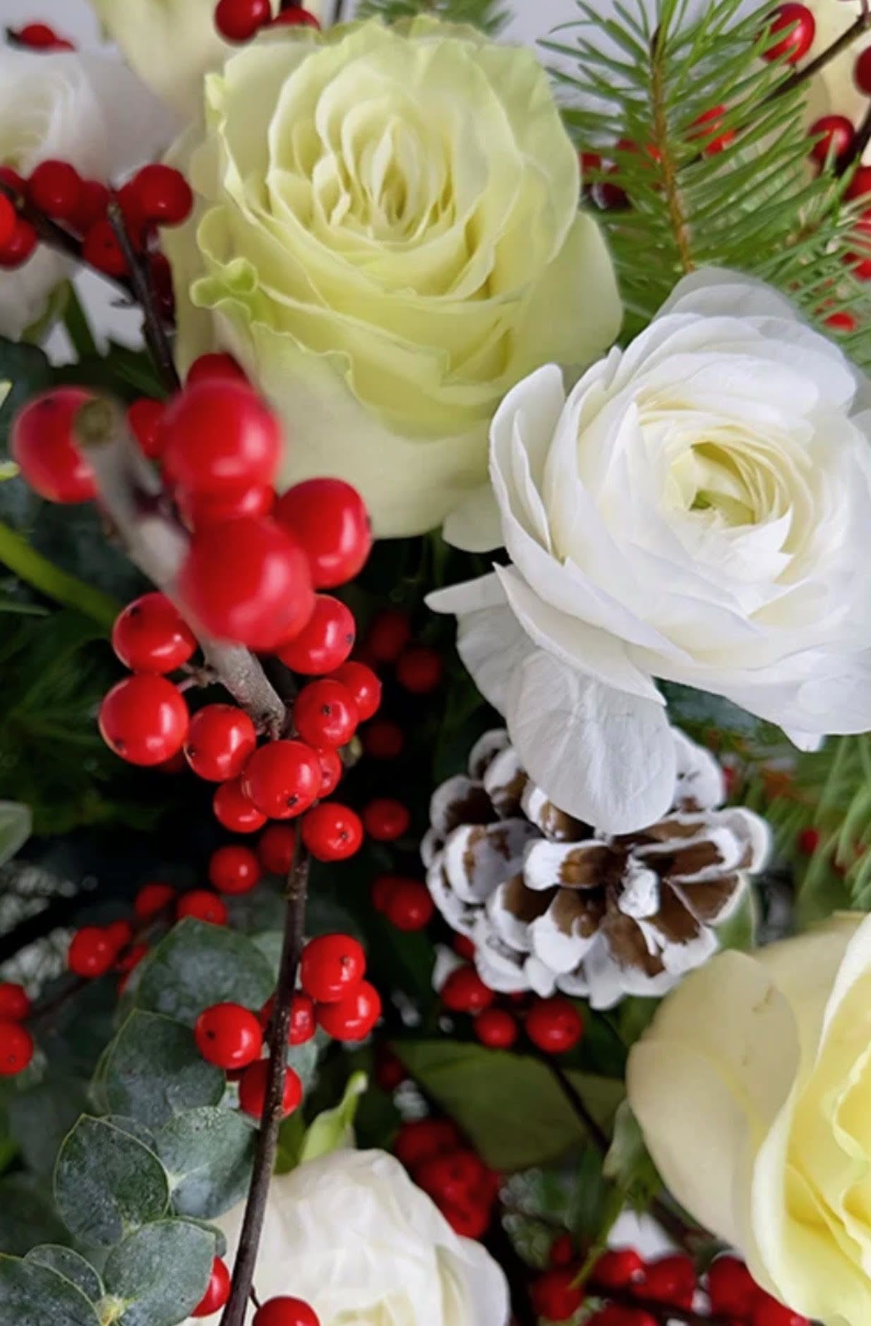 Designers Choice Table Center - Let the designer decide using the freshest and most gorgeous seasonal blooms to create a beautiful Christmas centerpiece. Each arrangement is thoughtfully handcrafted with artistic freedom, highlighting holiday textures, rich colors, and festive accents. Designed low and table-friendly, it adds warmth and elegance to your celebration while allowing conversation to flow. Every piece is one of a kind, capturing the spirit of Christmas through expert design and the best materials available.