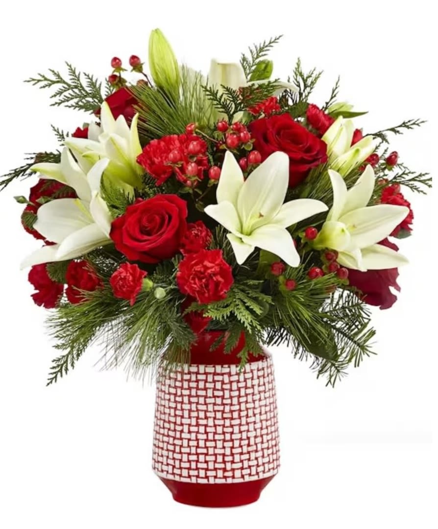 Sweet Joy Bouquet - Add some "sweet joy" to the holidays this year with this popular red, white and green bouquet. A red ceramic vase with raised white woven pattern holds a classic red and white Christmas palette of blooms. Flowers include white Asiatic lilies, red roses and red carnations. Extras include red hypericum berries and assorted seasonal greens like cedar, pine and spruce.