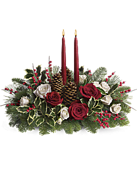 Christmas Wishes Centerpiece - Your wishes for a classic Christmas centerpiece have come true! This elegant arrangement features two glowing red taper candles atop a bed of Christmas greens and luxurious roses.  Standard shown.