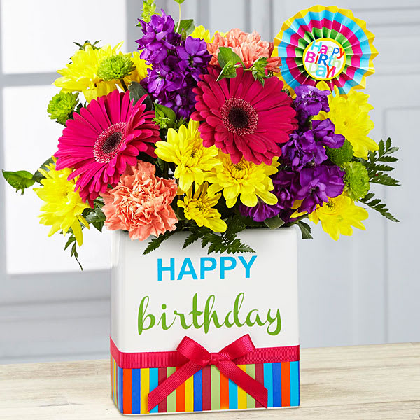  Birthday Brights Bouquet -  Birthday Brights Bouquet is a true celebration of color and life to surprise and delight your special recipient on their big day! Hot pink gerbera daisies and orange roses take center stage surrounded by purple gilly flowers yellow chrysanthemums orange carnations green button poms bupleurum and lush greens to create party perfect birthday display. Presented in a modern rectangular ceramic vase with colorful striping at the bottom "Happy Birthday" lettering at the top and a bright pink bow at the center this unforgettable fresh flower arrangement is then accented with a striped happy birthday pick to create a fun and festive gift. 