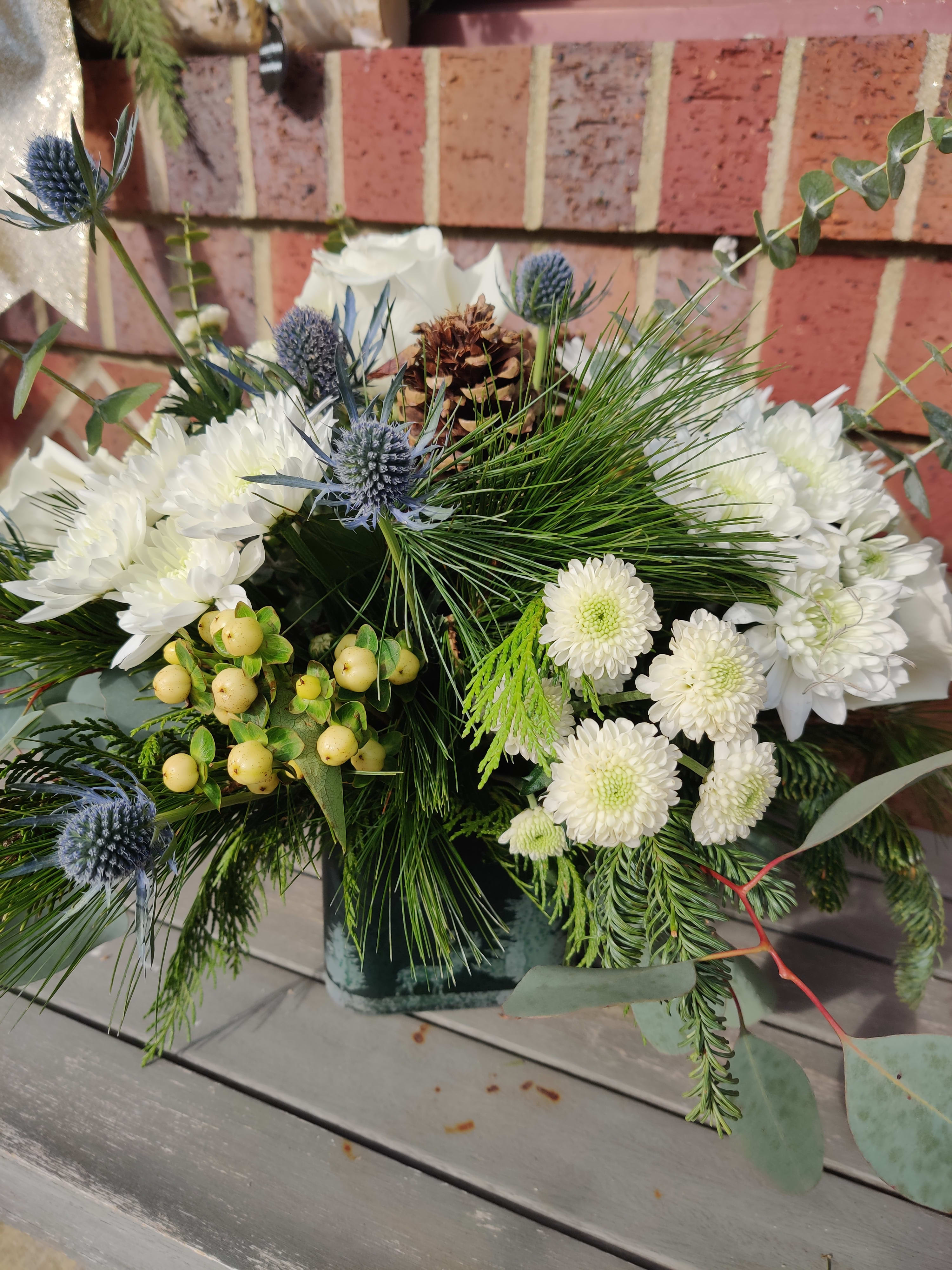Winter wonderland - A beautiful cube candle holder with winter scene is the base for an all white arrangement cones and assorted Christmas greend