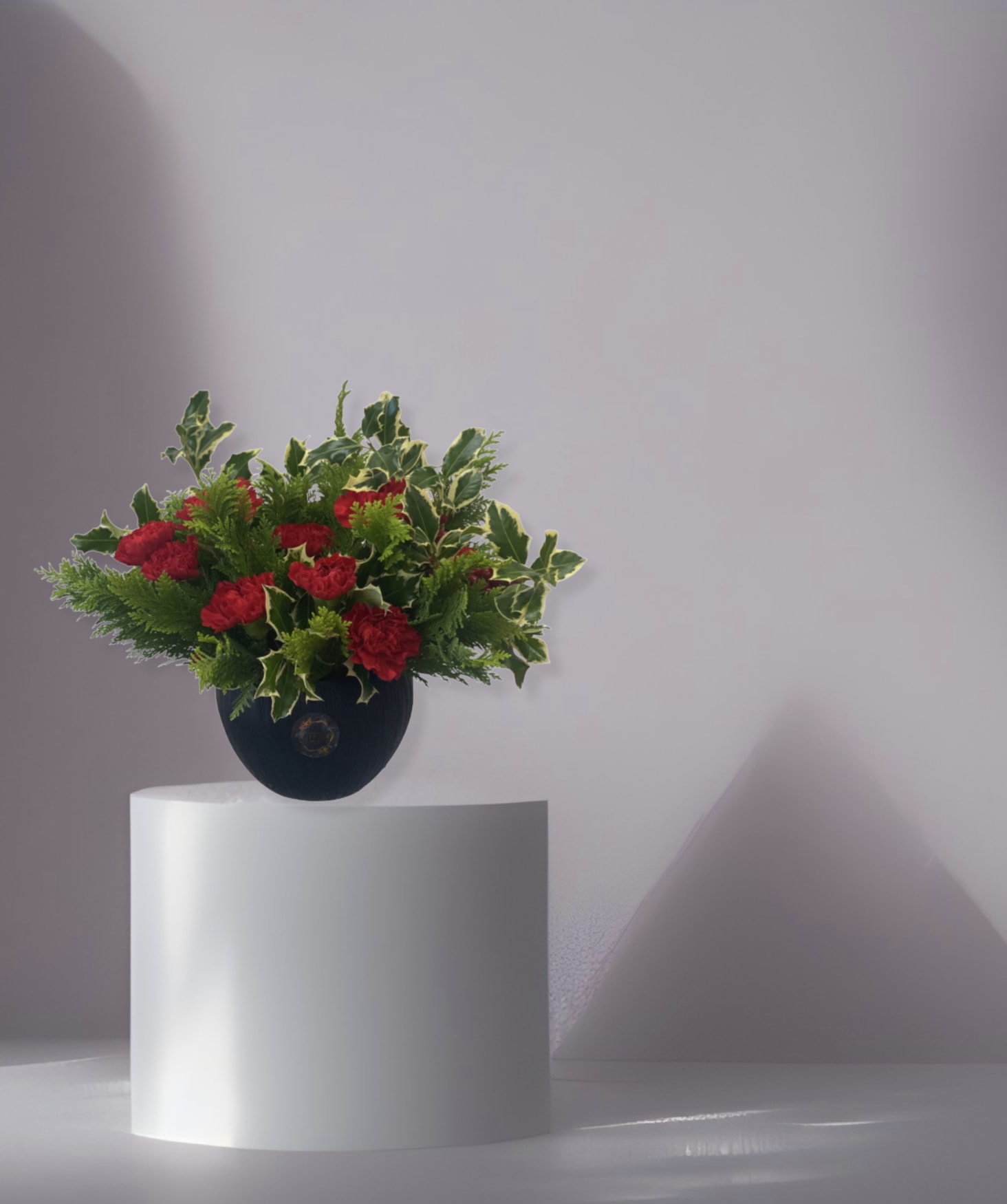 Carmine - The arrangement comes in a unique vase name; coconut. The arrangement comes with the following florals carnations and holiday greenery. 