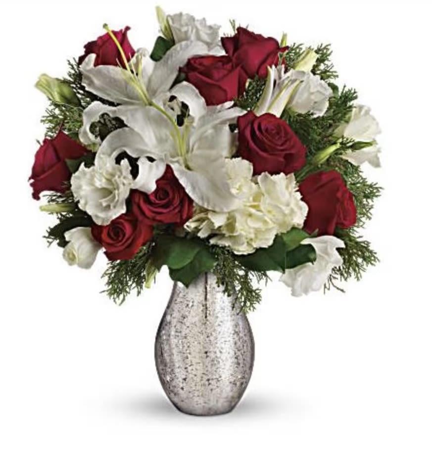 A Christmas Kiss by Teleflora - Capture the romance of the season! Wonderful white hydrangea and rich red roses fill our stunning silver mercury glass royal vase. White hydrangea, red roses, white oriental lilies and white lisianthus are accented with flat cedar. Orientation: All-Around