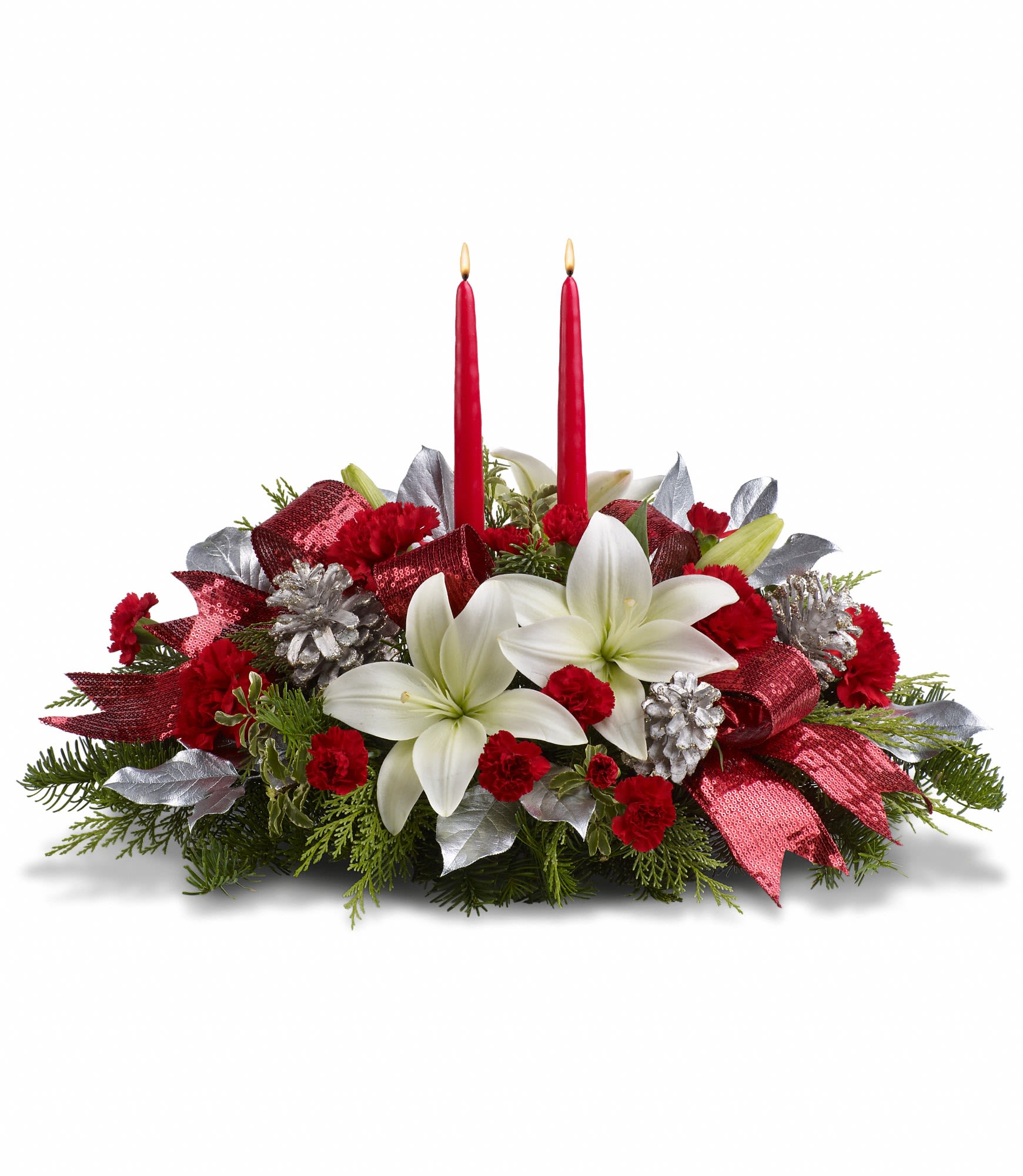 Lights Of Christmas Centerpiece - Shiny and bright! Holiday celebrations shine with this lush arrangement of snow white lilies and red carnations beautifully arranged with fresh holiday greens, silver pinecones and glistening red ribbon.