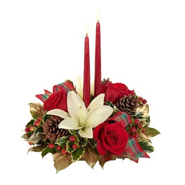 Home For The Holidays Centerpiece - Asiatic lilies, roses, hypericum and carnations are blended creatively in an oval bowl container with pine cones, a plaid ribbon and two Patrician tapered candles to form an absolutely stunning holiday centerpiece that will welcome home loved ones and friends while artfully capturing the many joys of the Christmas season. Measures 8”H X 15”L.