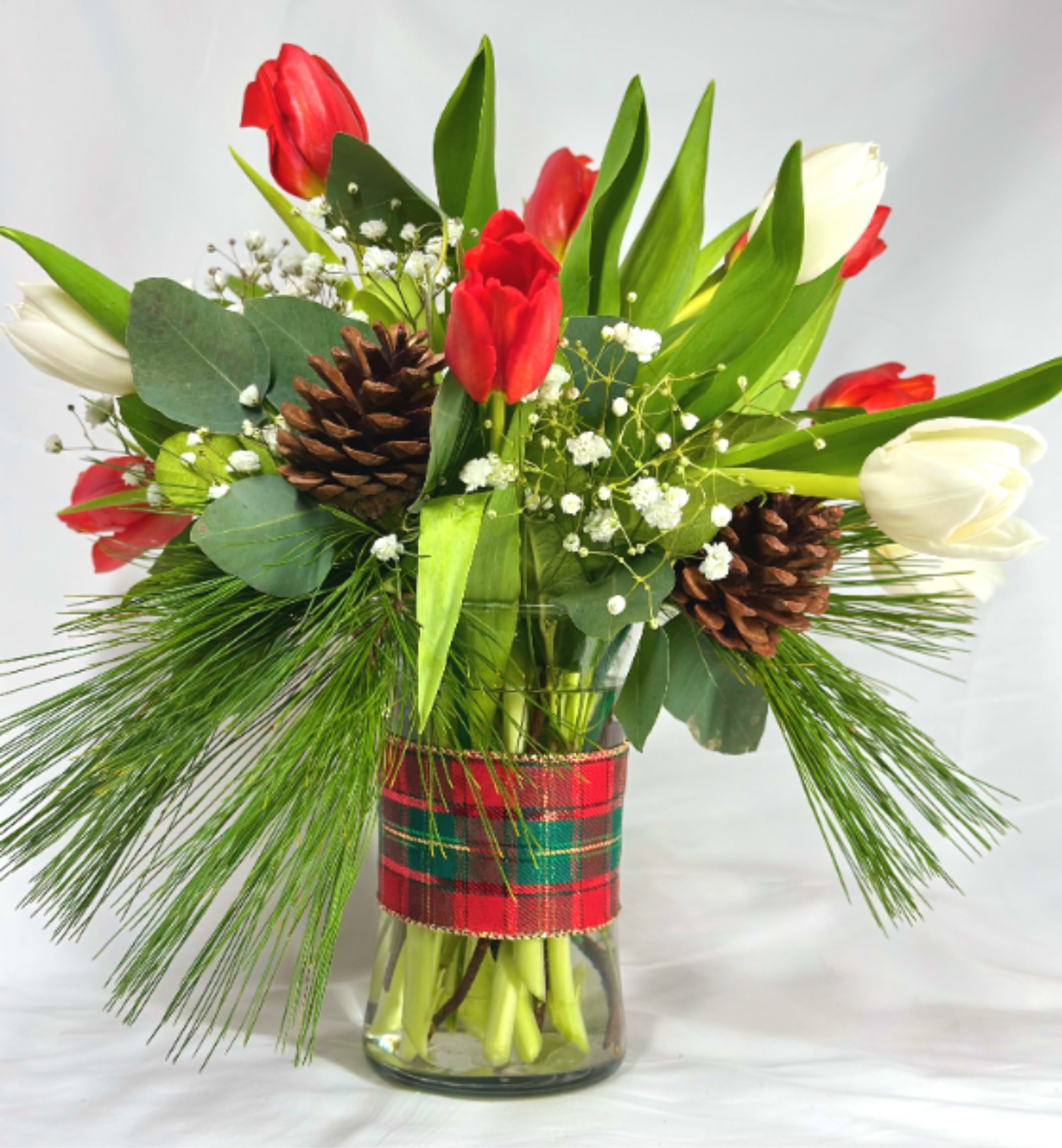Tartan Tulips - What is more festive than a seasonal arrangement of red and white tulips with holiday decorations and greenery? The tartan plaid bow really makes this Christmas arrangement sparkle.