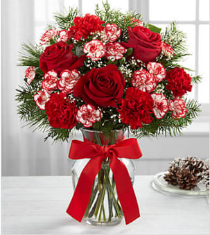 The Goodwill &amp; Cheer Bouquet - The  Goodwill &amp; Cheer Bouquet blooms with holiday joy and seasonal beauty to create the perfect gift for your special recipient. Rich red roses, red carnations, peppermint red and white mini carnations, Baby's Breath and a lush assortment of holiday greens are brought together to create a fresh flower arrangement that is both merry and bright. Presented in a clear glass vase tied with a red ribbon at the neck, this holiday flower bouquet is a spectacular way to spread your goodwill and cheer to friends, family and co-workers throughout the Christmas season. BETTER bouquet is approximately 17"H x 15"W. Your purchase includes a complimentary personalized gift message.