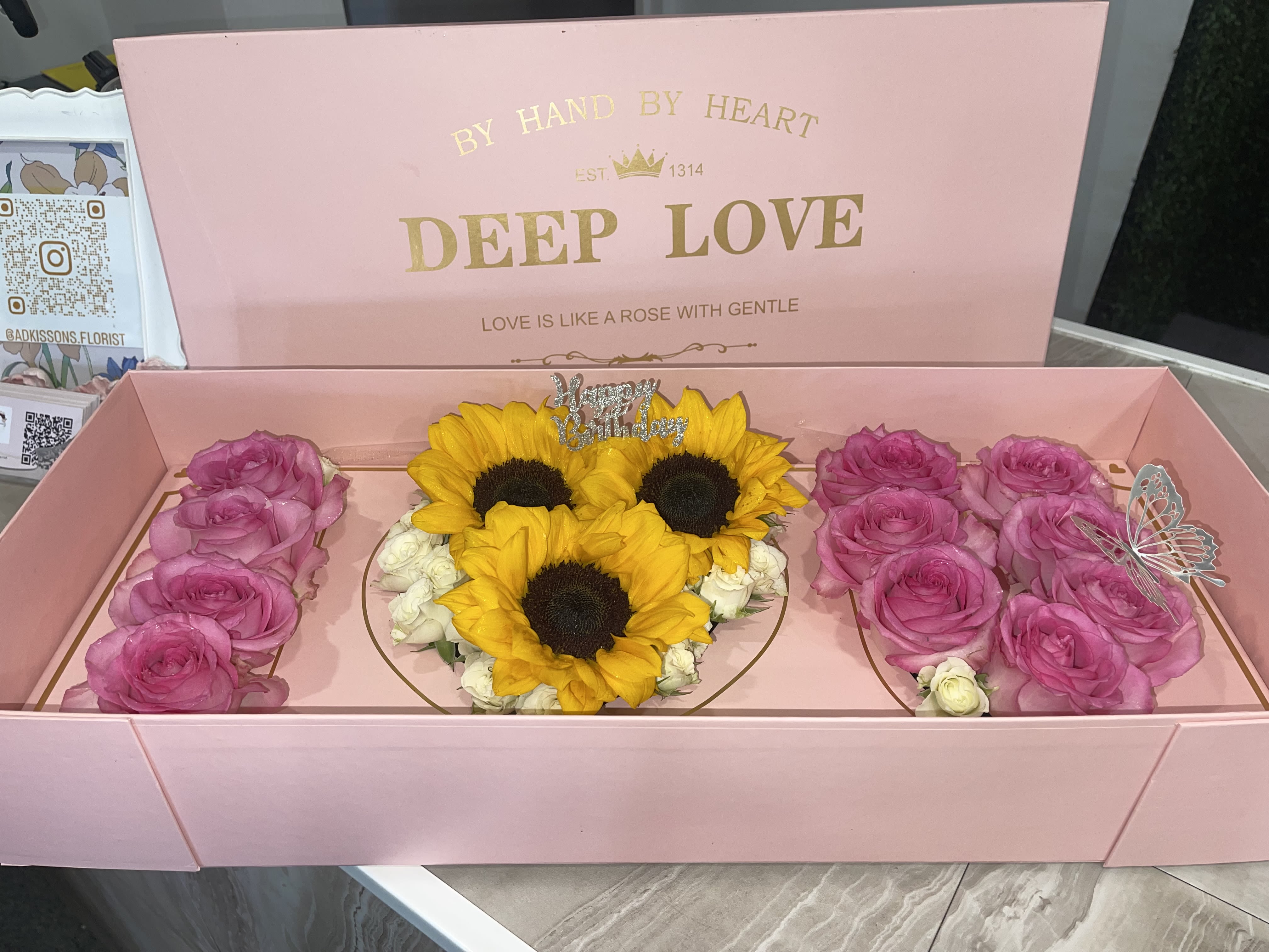 Pink I Love You Box - Enhance the romance of your special day with the Pink Love Box, adorned with a lovely floral inscription that reads "I LOVE YOU." This delightful arrangement combines soft pink tones some yellow sunflowers with a classic message of love, crafting a breathtaking visual that truly resonates from the heart.