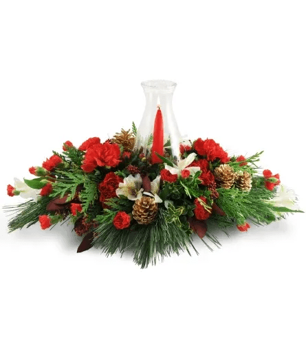 Warming Glow - Ready to kick off the holiday season? Add a warm, welcoming glow to a loved one’s home (or your own!) with this artfully arranged centerpiece.  Carnations, alstroemeria, pinecones, cedar, and more are topped with a taper candle in a delicate hurricane glass.