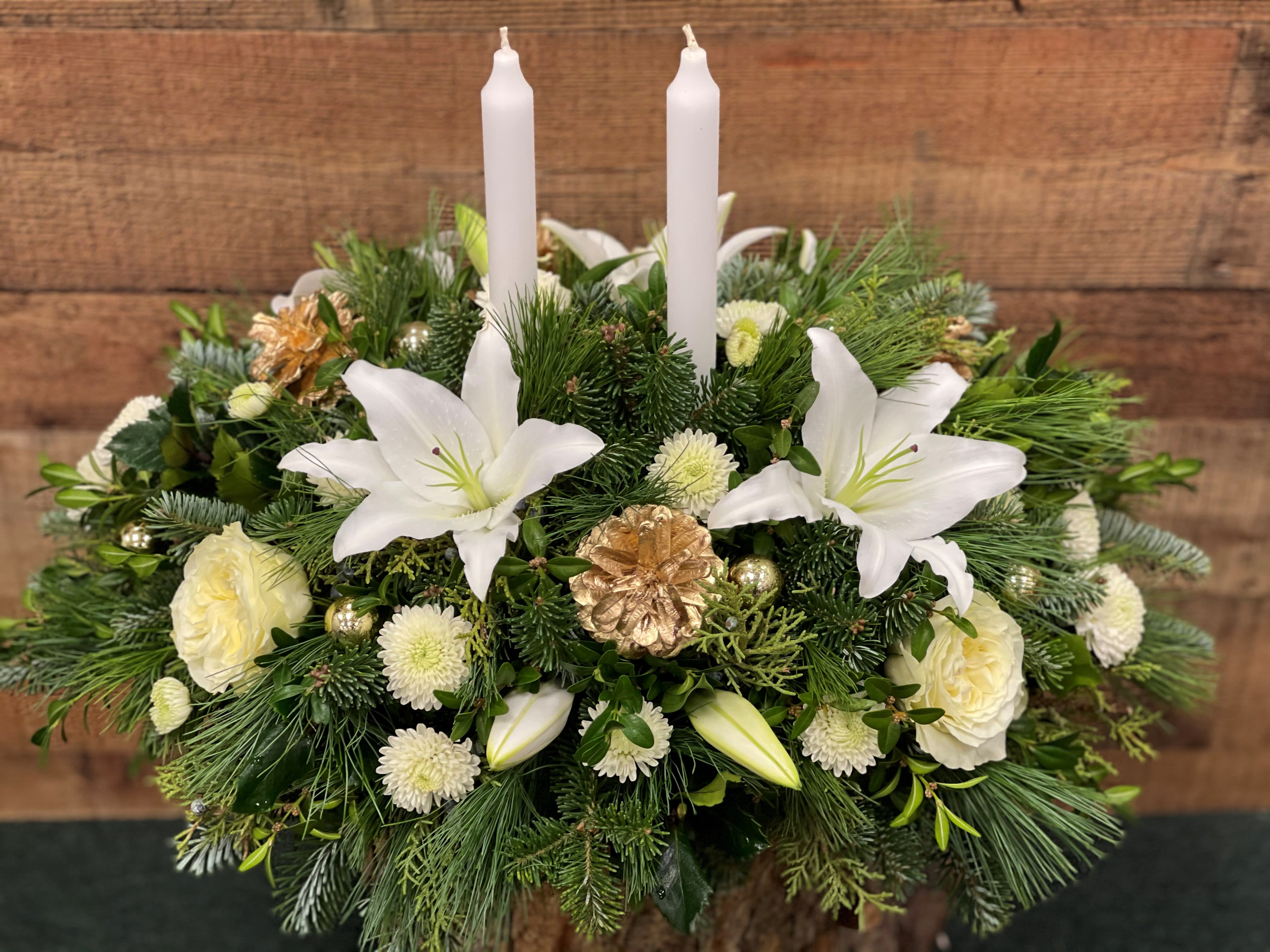 Winter White Candled Centerpiece  - These elegant white lilies and luscious garden roses are adorned with gold accents and aglow with candles for the center of any table. 